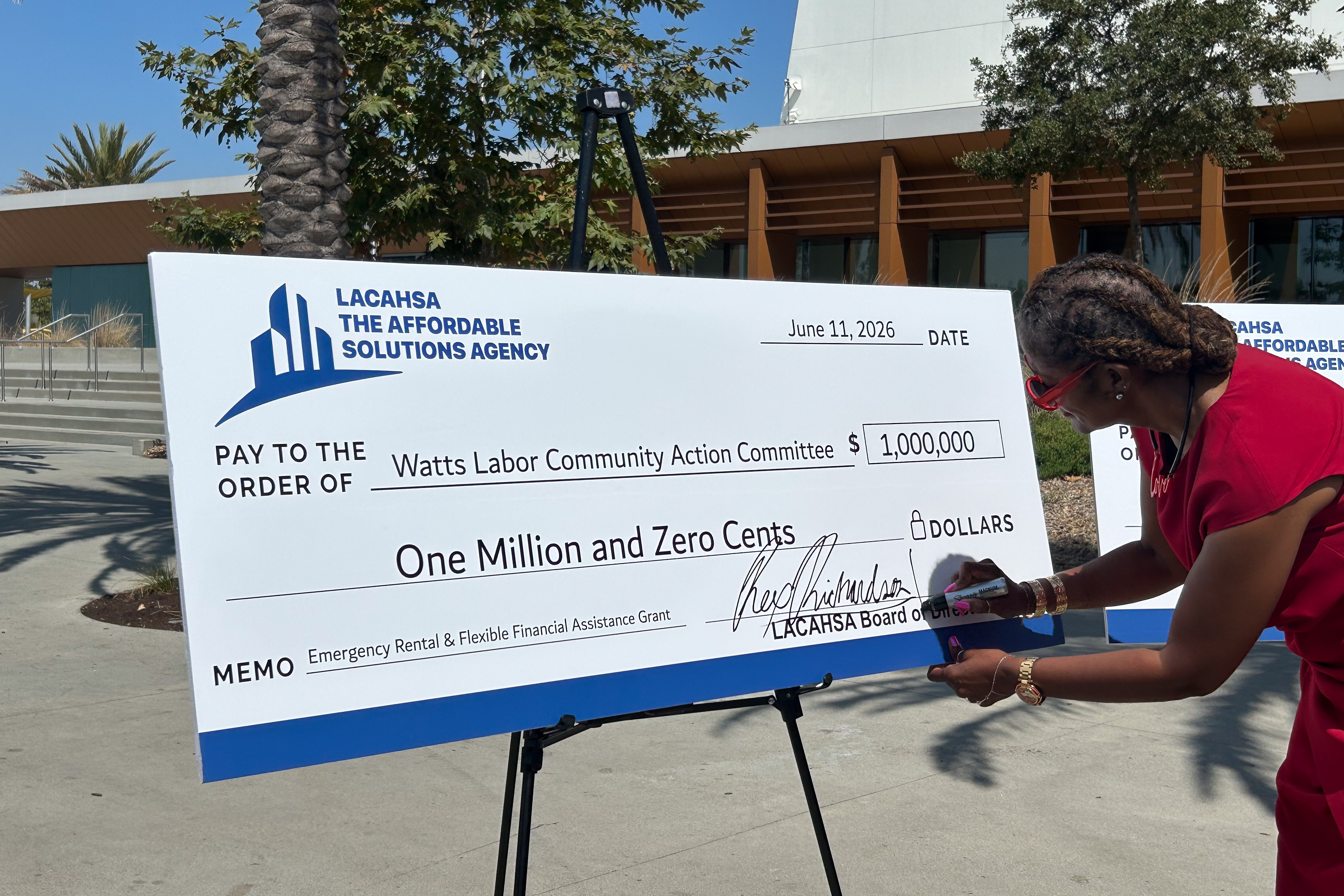Los Angeles County Supervisor Holly J. Mitchell signs the checks...