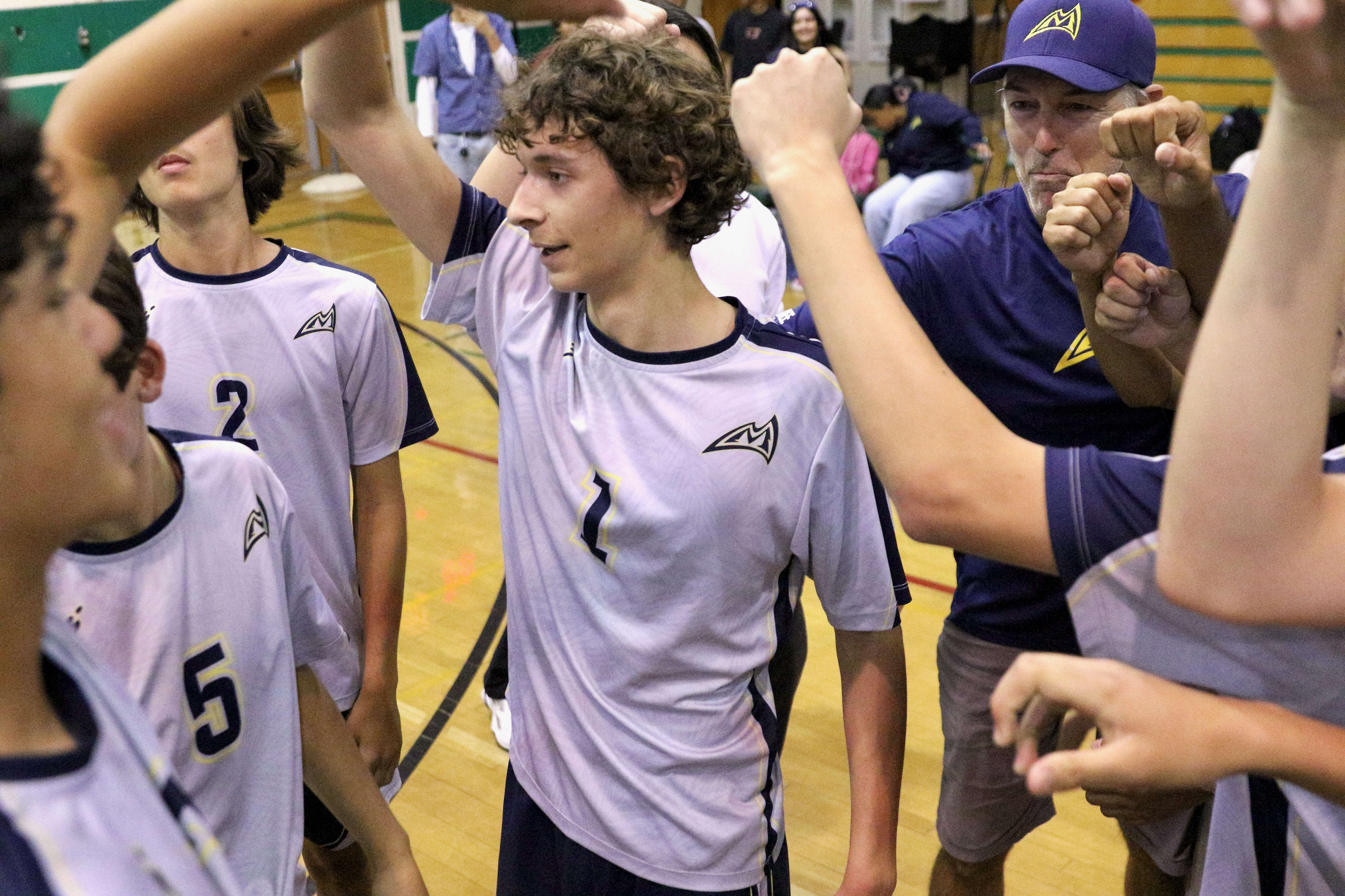 Millikan senior outside hitter Jacob Karkanen, center, and head volleyball...