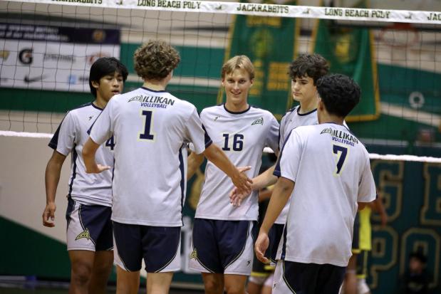 Millikan players gather around Evan Crucil Chambers, center, after a point in the Rams' three-set sweep over Poly to clinch the Moore League title on Wednesday, Apr. 22, 2026, at Poly High School in Long Beach. (Photo by Howard Freshman, Contributing Photographer)