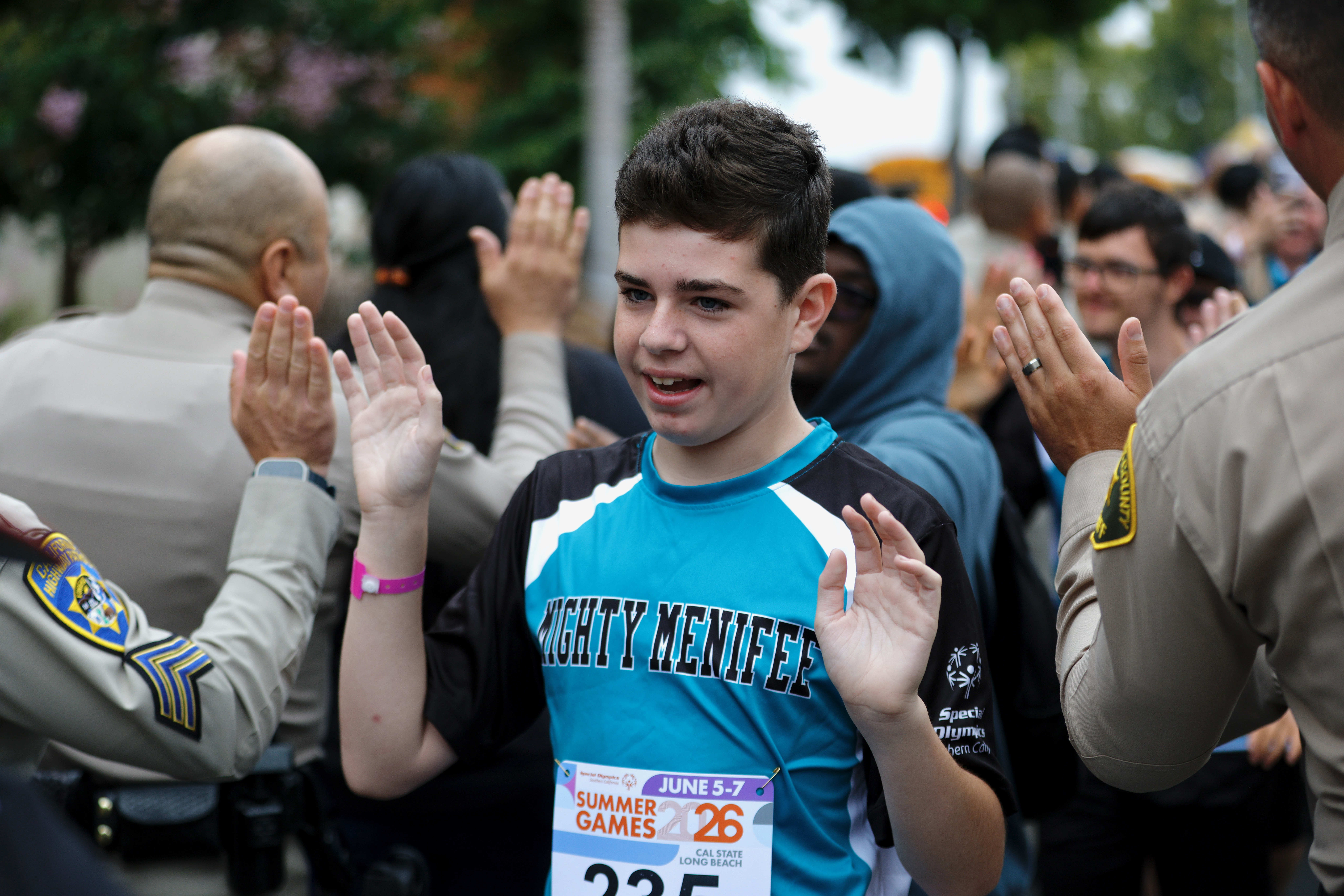 Athletes are greeted by scores of law officers as the...