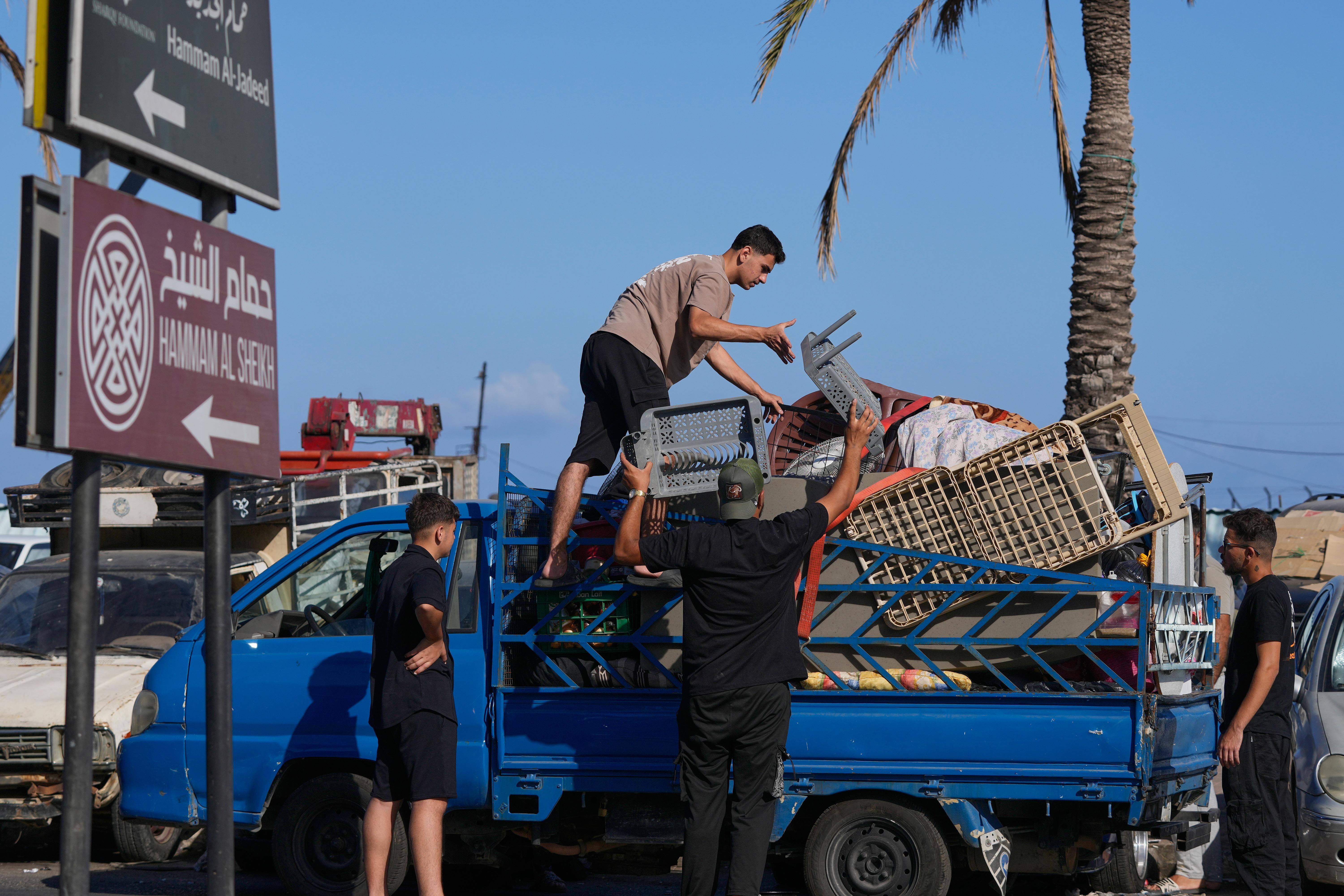Displaced people pack their belongings as they prepare to return to their village in Lebanon.