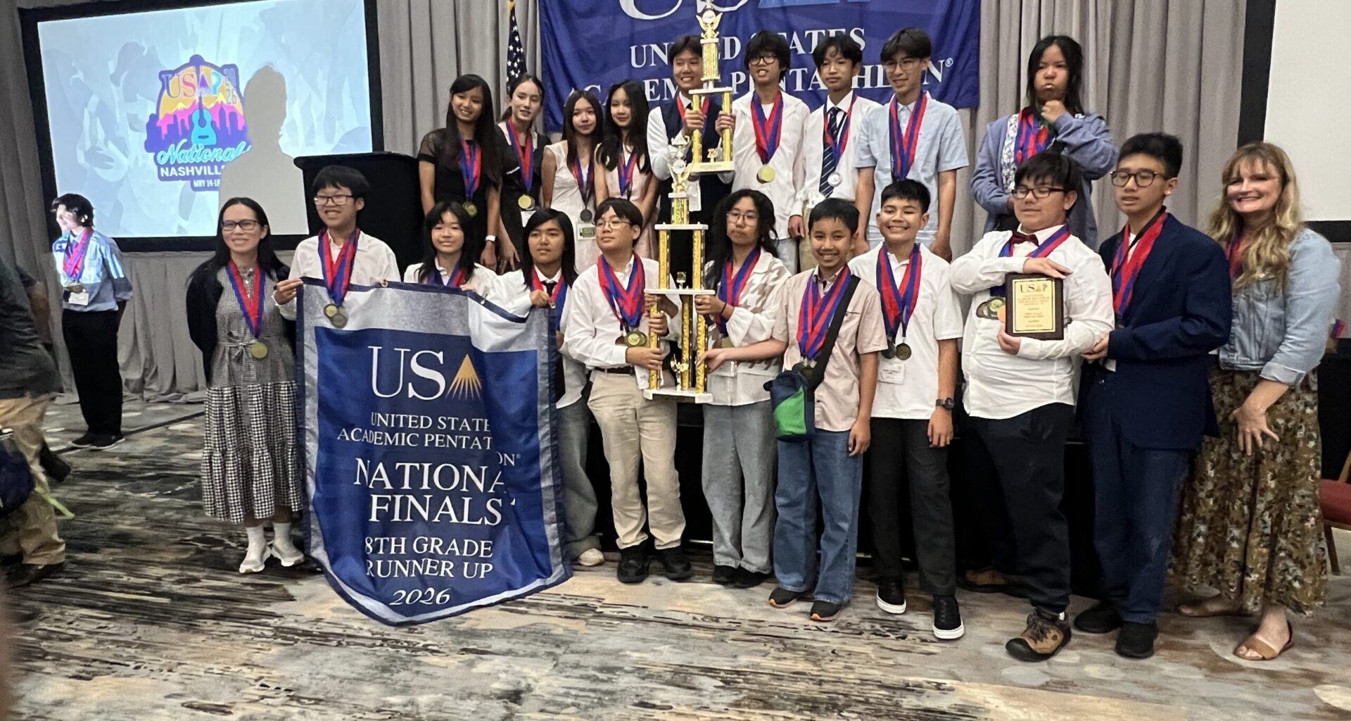 Students from McGarvin Intermediate School pose with medals and trophies during an awards ceremony at the 2026 United States Academic Pentathlon National Finals in Nashville, Tennessee.