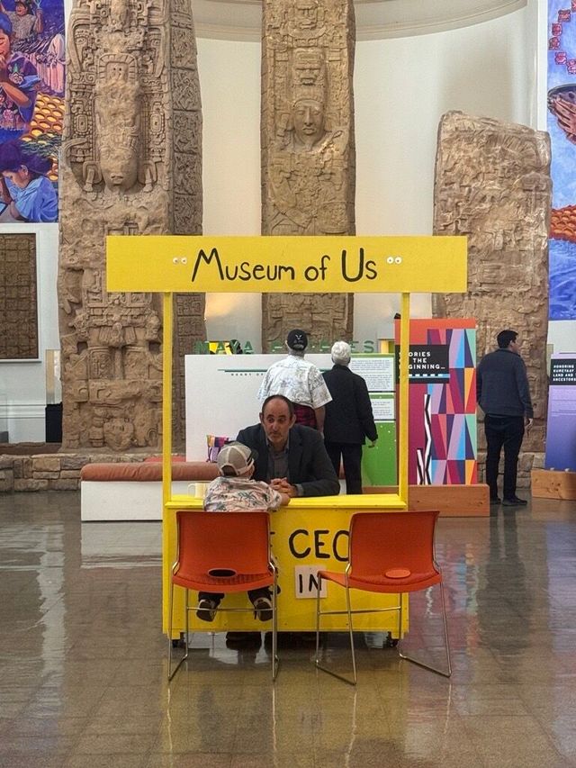 Micah Parzen sits behind a Peanuts-style booth that says "The CEO is In."