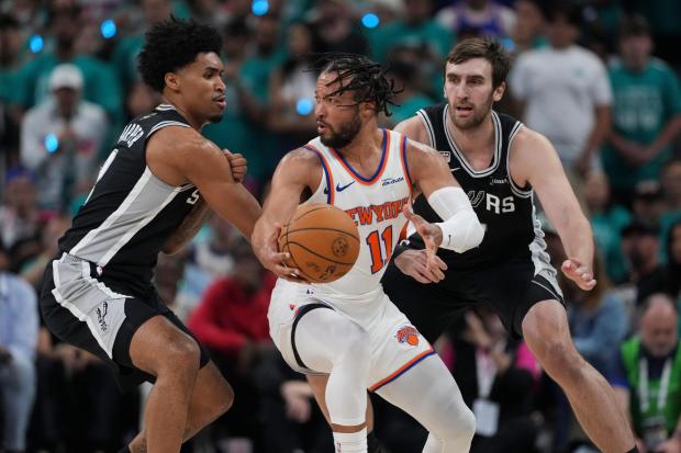 New York Knicks guard Jalen Brunson (11) spins as San Antonio Spurs guard Dylan Harper, left, defends during the first half of Game 1 of the NBA Finals basketball series, Wednesday, June 3, 2026, in San Antonio. (AP Photo/Eric Gay)