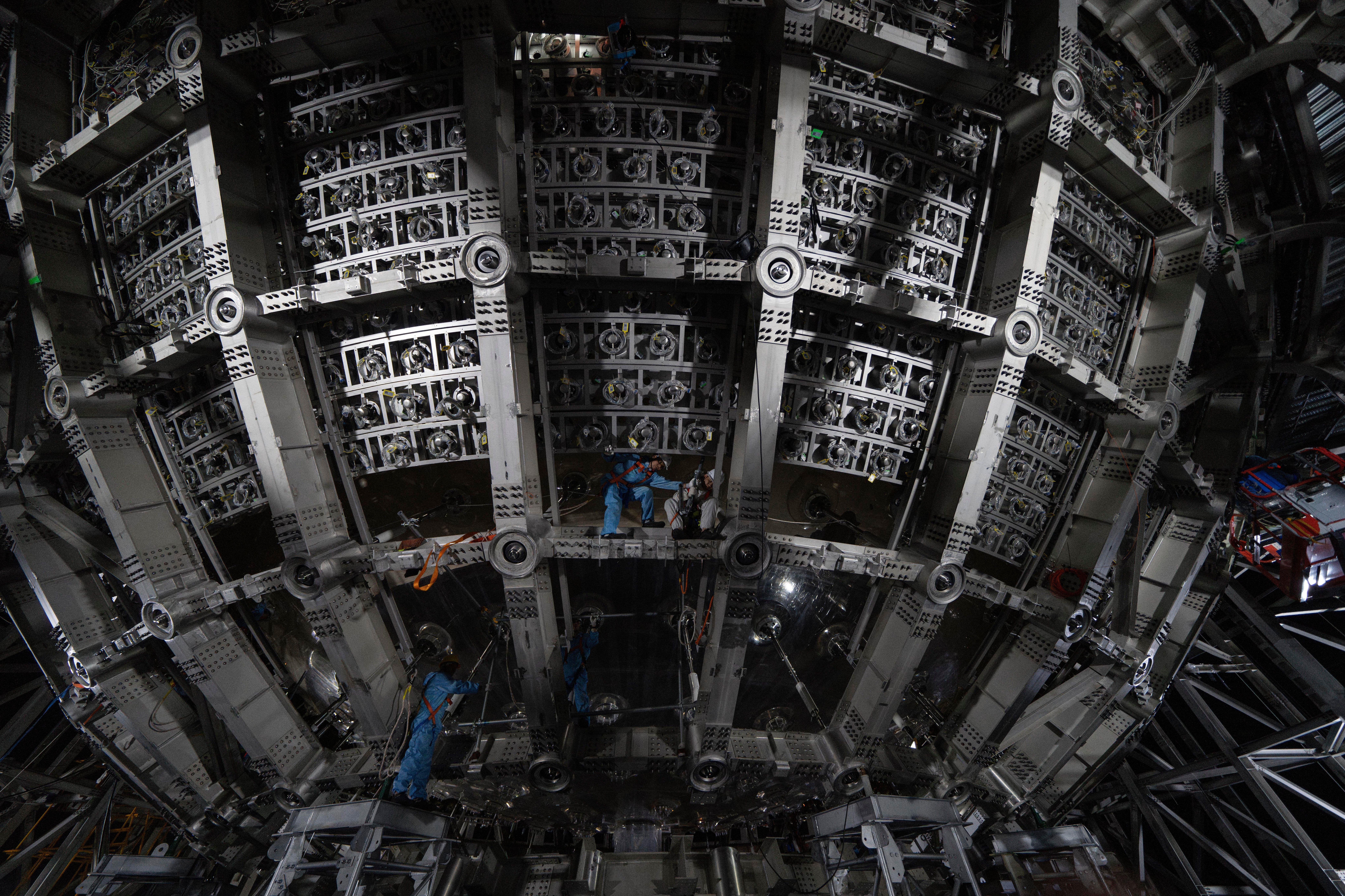 FILE – Workers labor on the underside of the cosmic...
