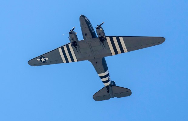 A vintage plane flies above Main Street in Huntington Beach during the 115th annual Fourth of July parade on Thursday morning, July 4, 2019. (Photo by Mark Rightmire, Orange County Register/SCNG)