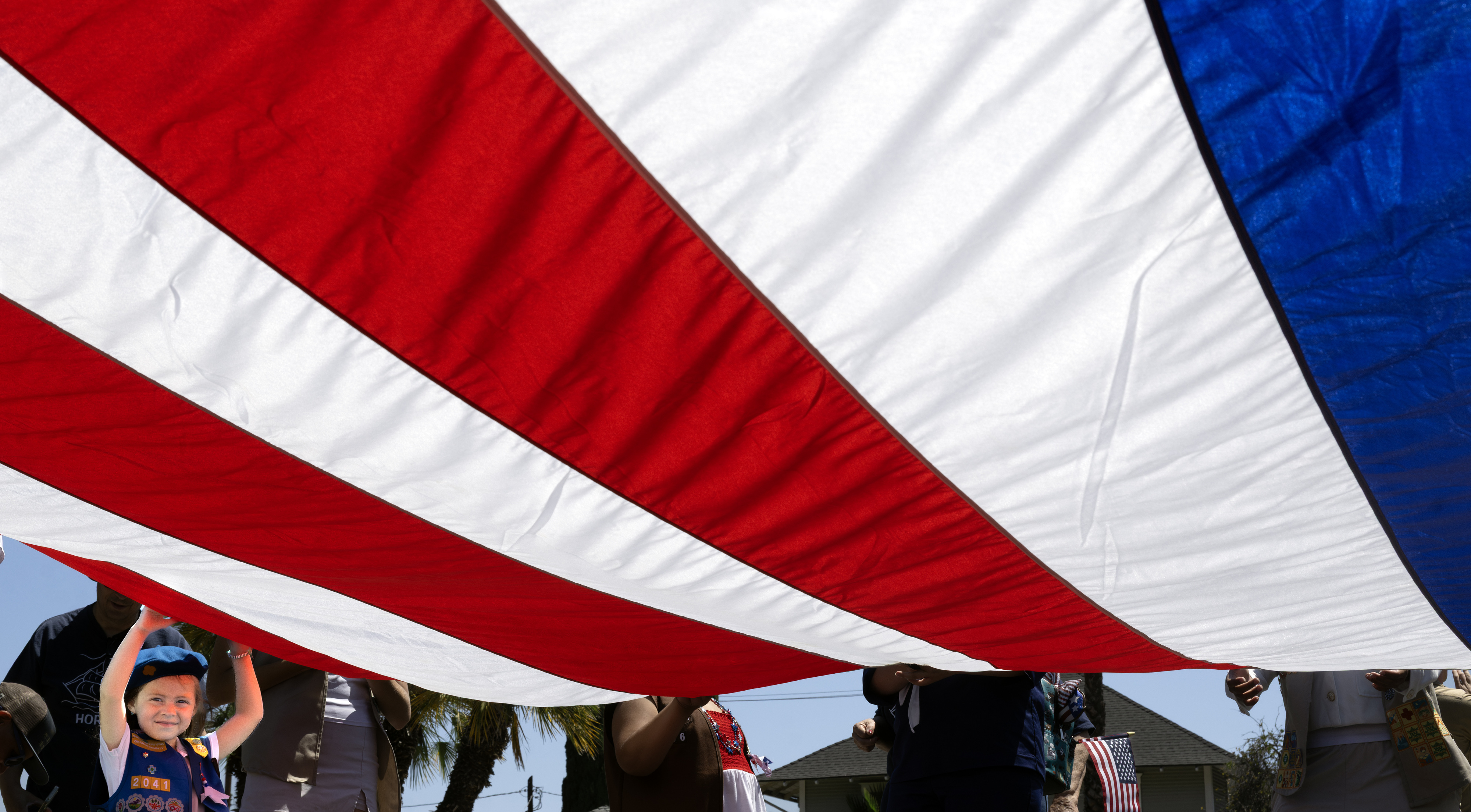 Four-year-old Remington Rivas holds Old Glory high as she and...
