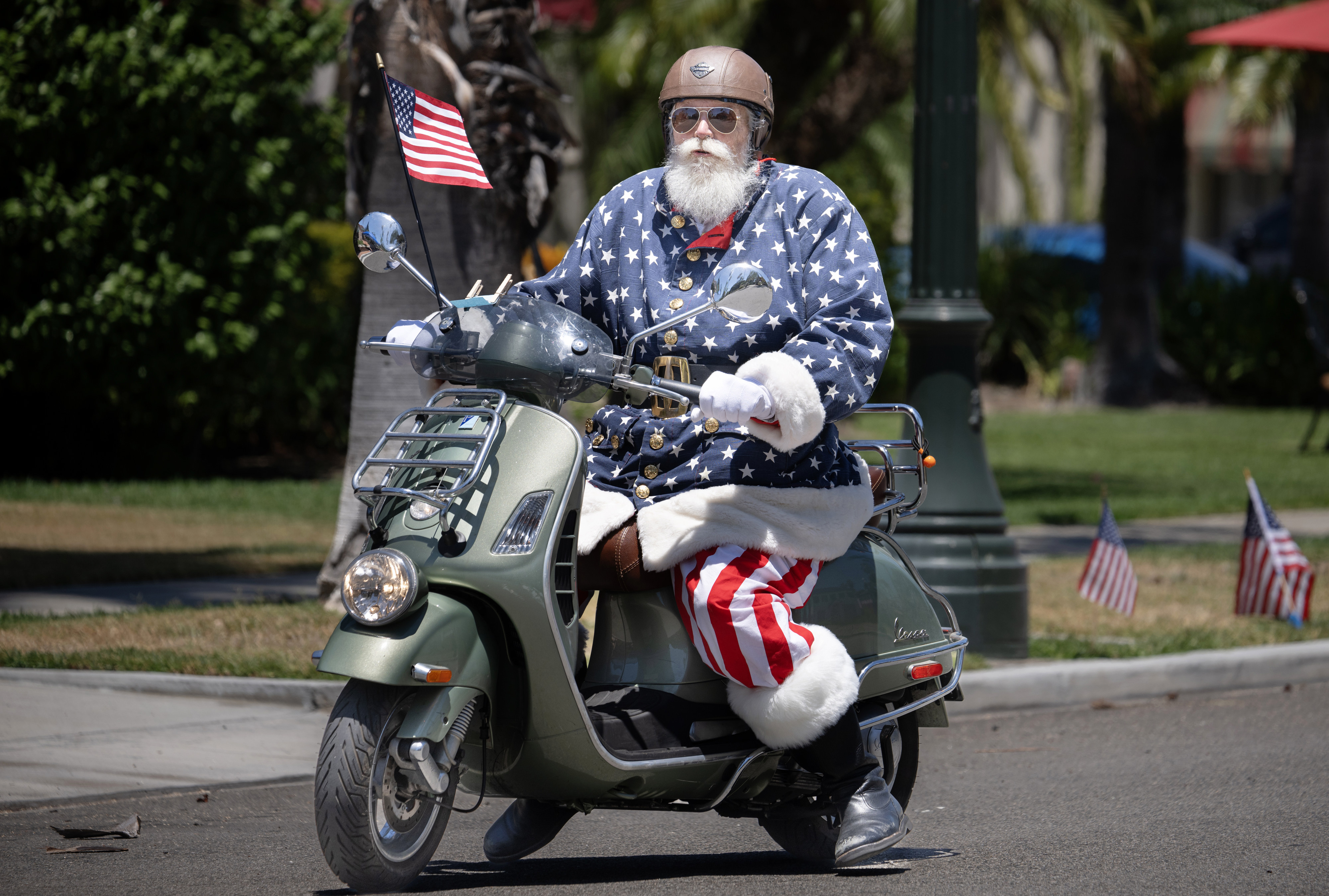 Patriotic Santa rolls into town on a scooter during the...