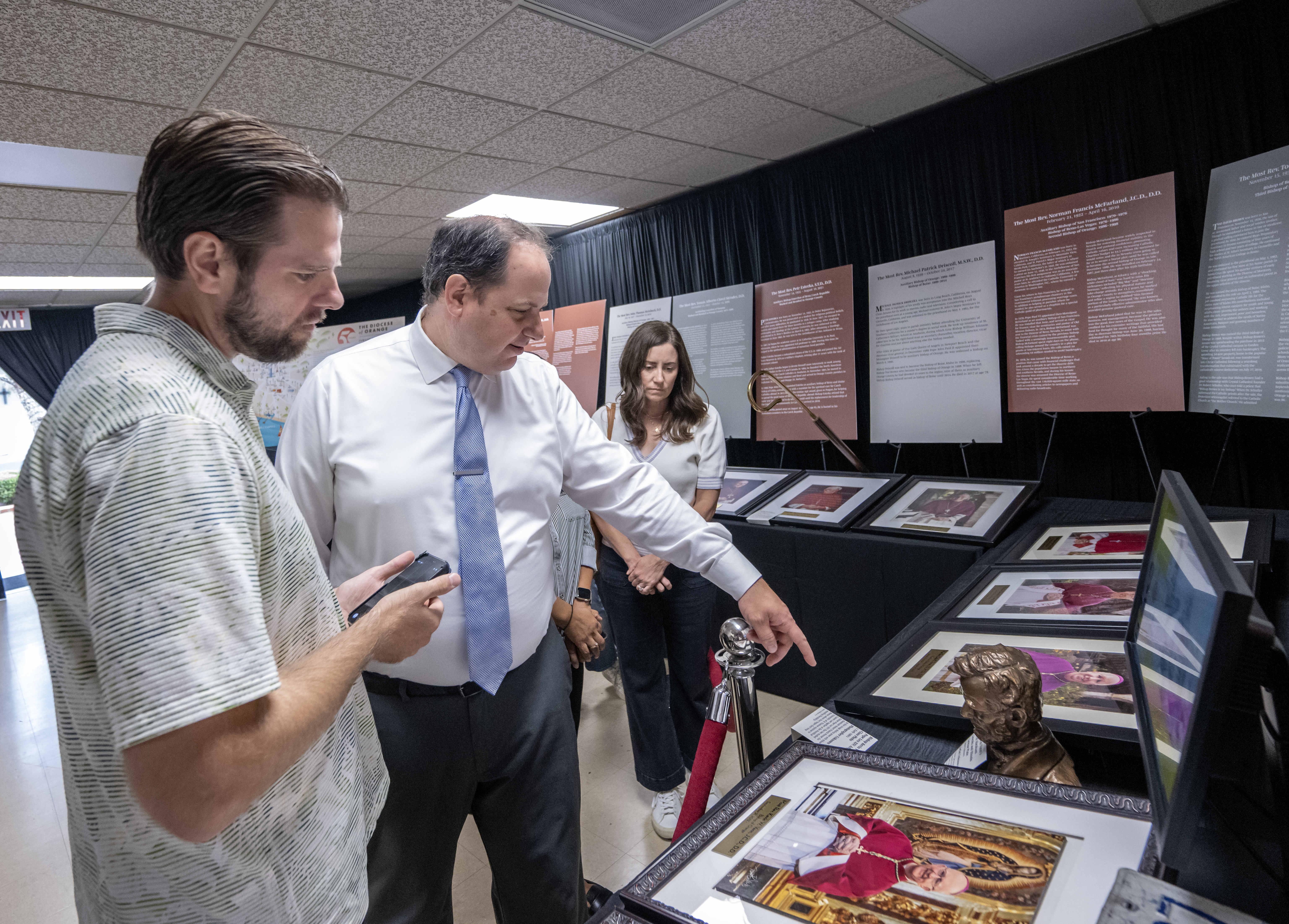 Bradley Zint, center, Assistant Director of Communications for the Roman...