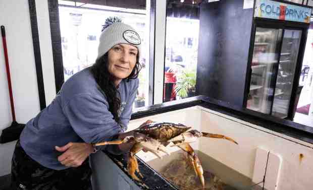 Shala Mansur-O'Keefe, owner of Jon's Fish Market, holds a Dungeness crab at the market and restaurant at the harbor in Dana Point, CA on Friday, December 30, 2022. (Photo by Paul Bersebach, Orange County Register/SCNG)