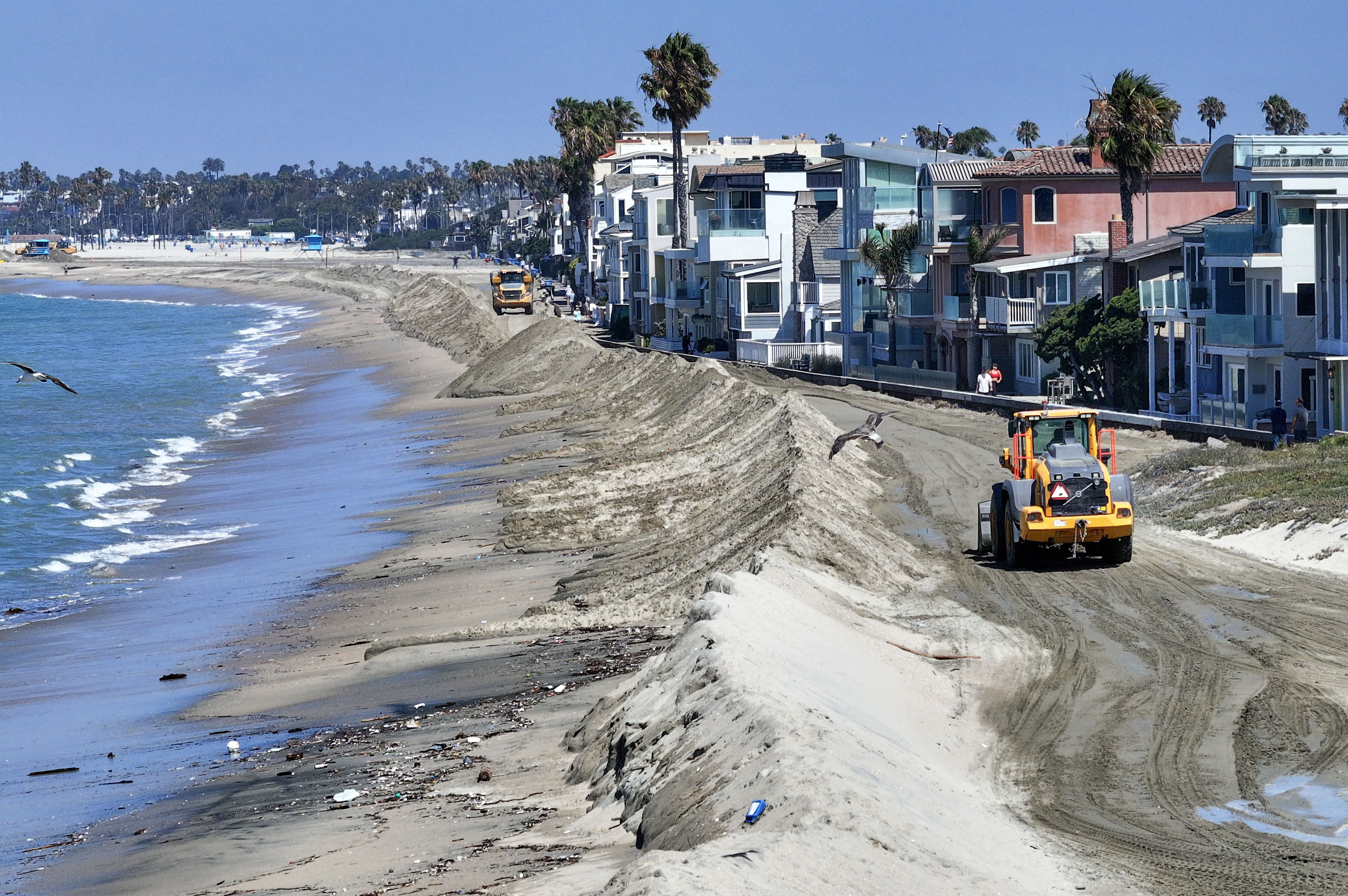 A berm is built in the sand to protect homes...