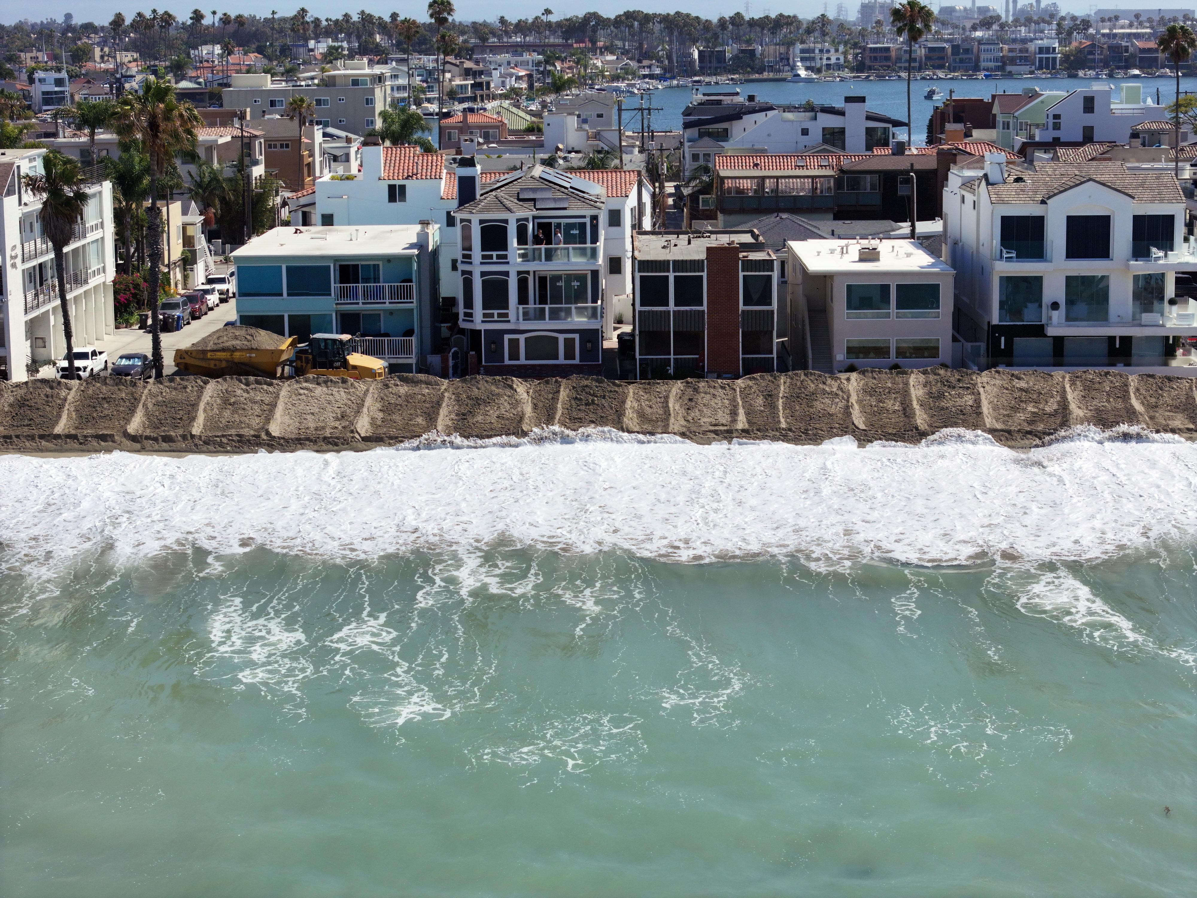 A berm is built in the sand to protect homes...