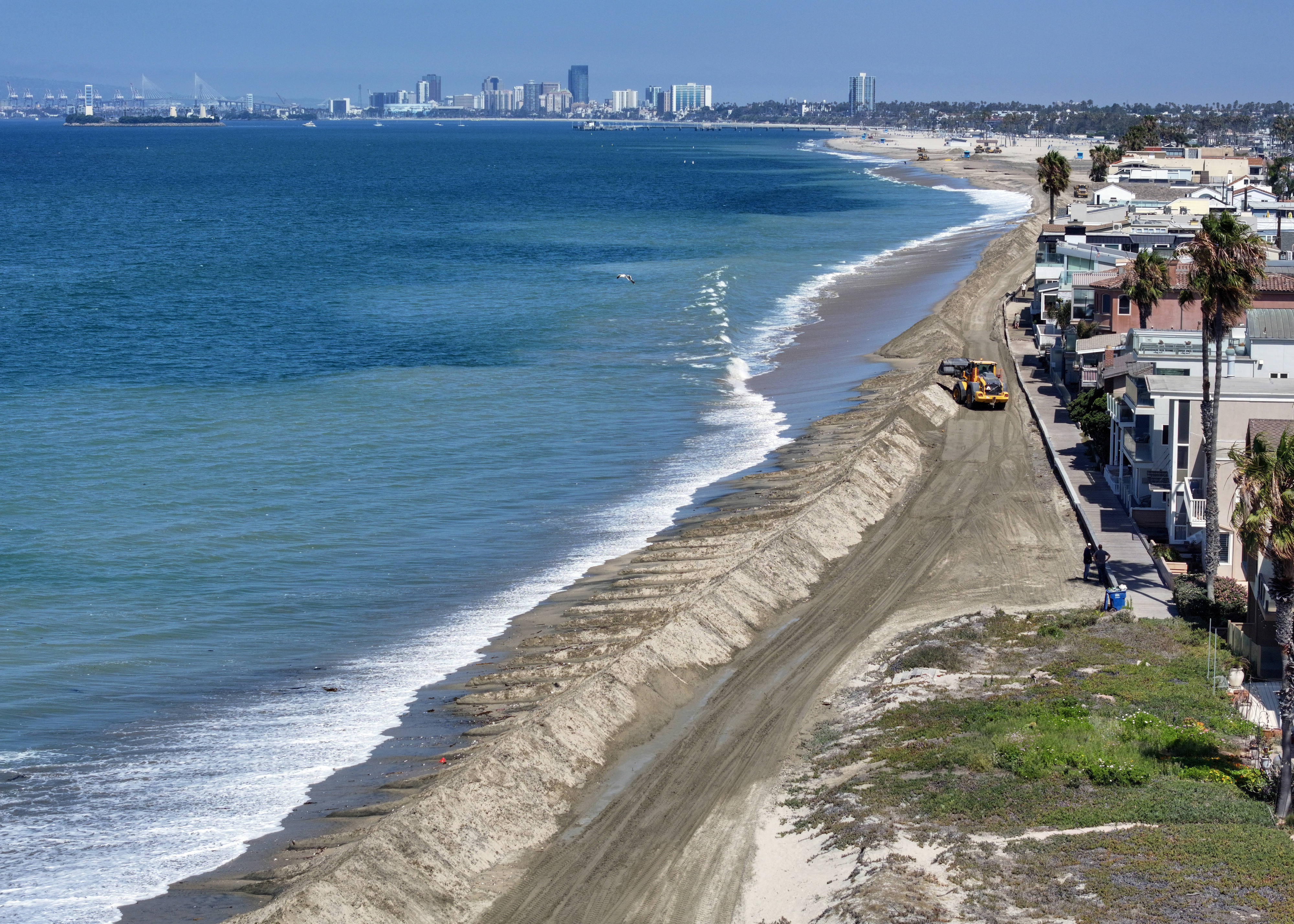 A berm is built in the sand to protect homes...