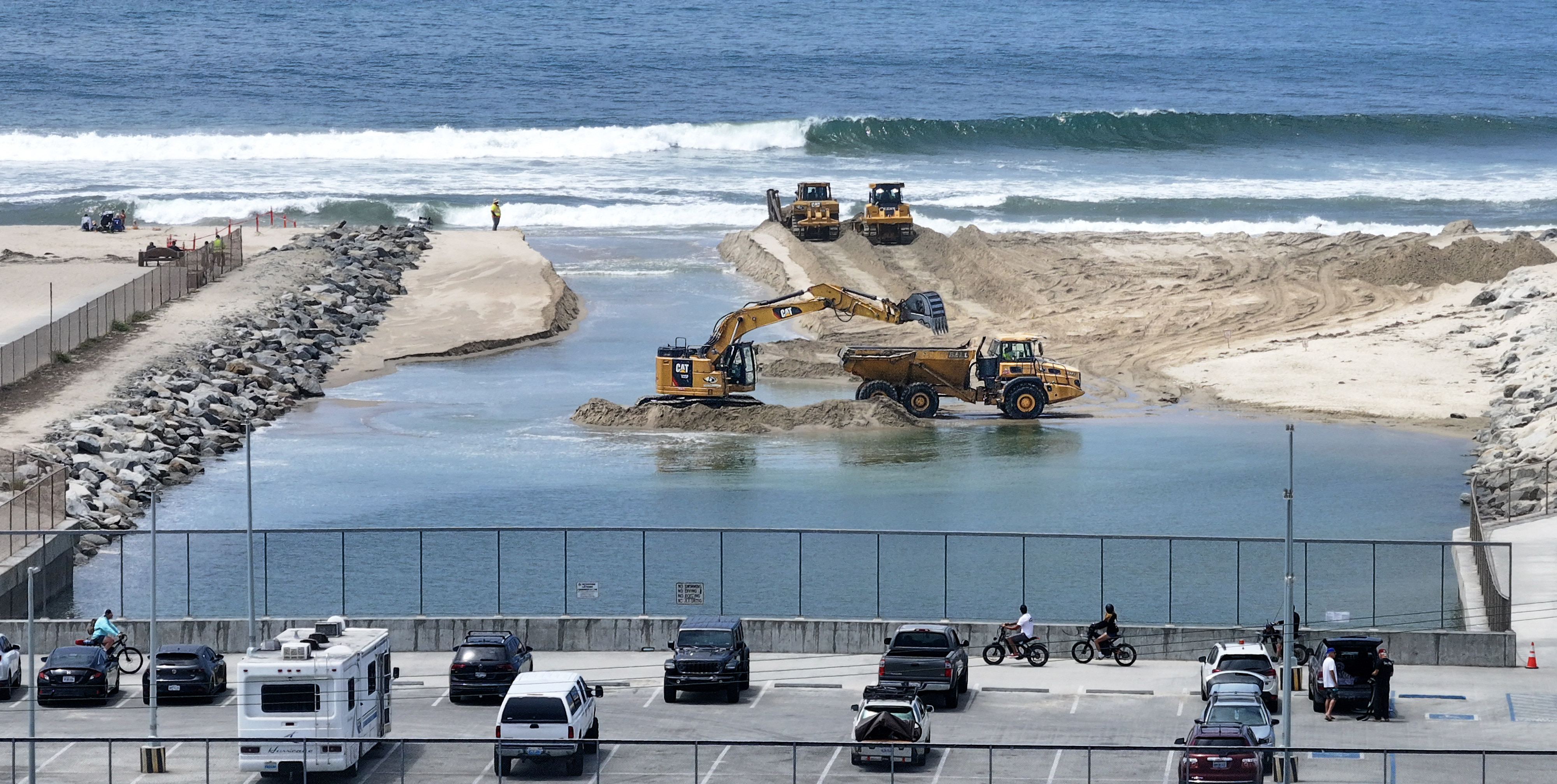 Workers clear sand from the opening between the Talbert Marsh...