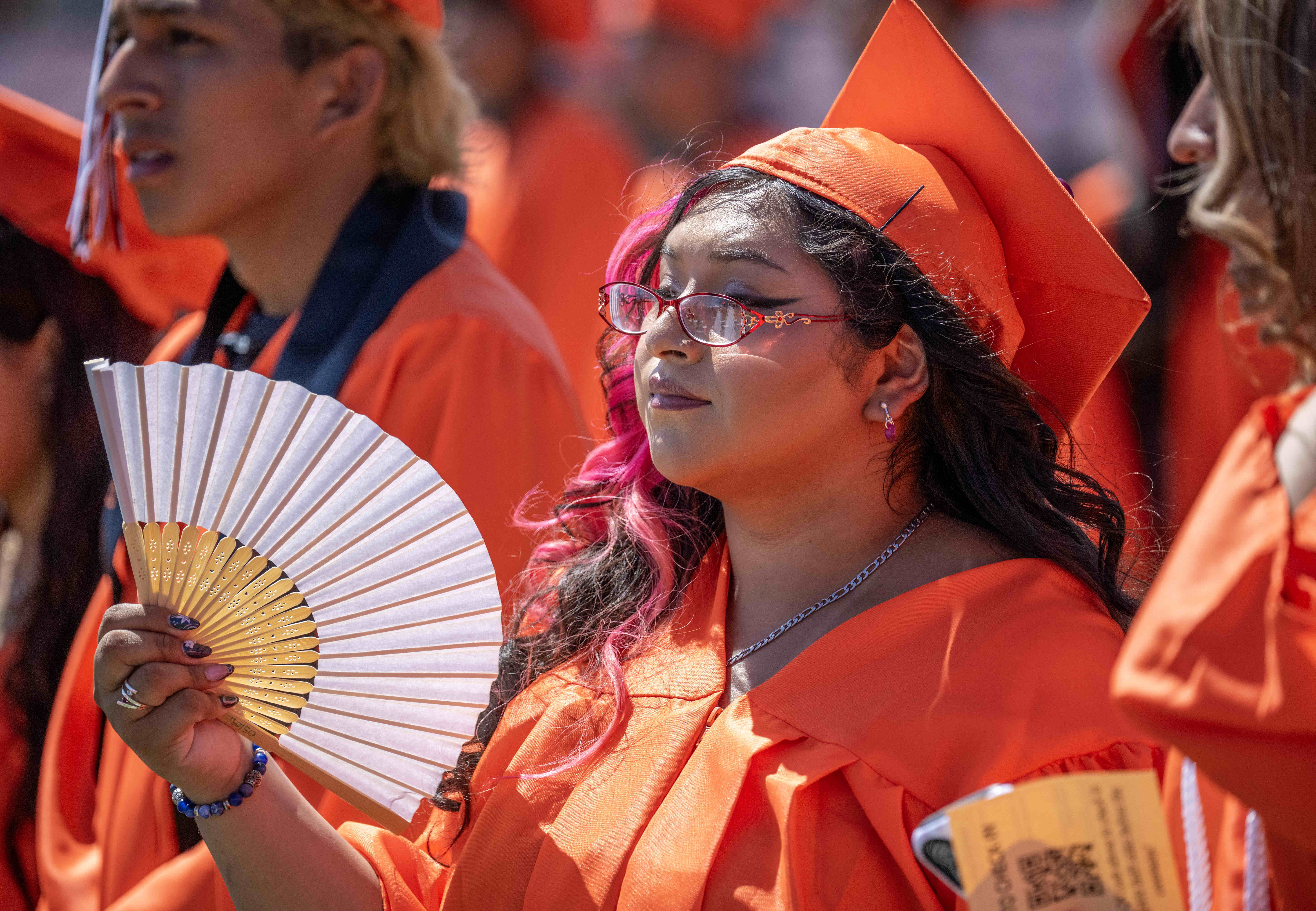One Orange High School graduate uses a fan to keep...