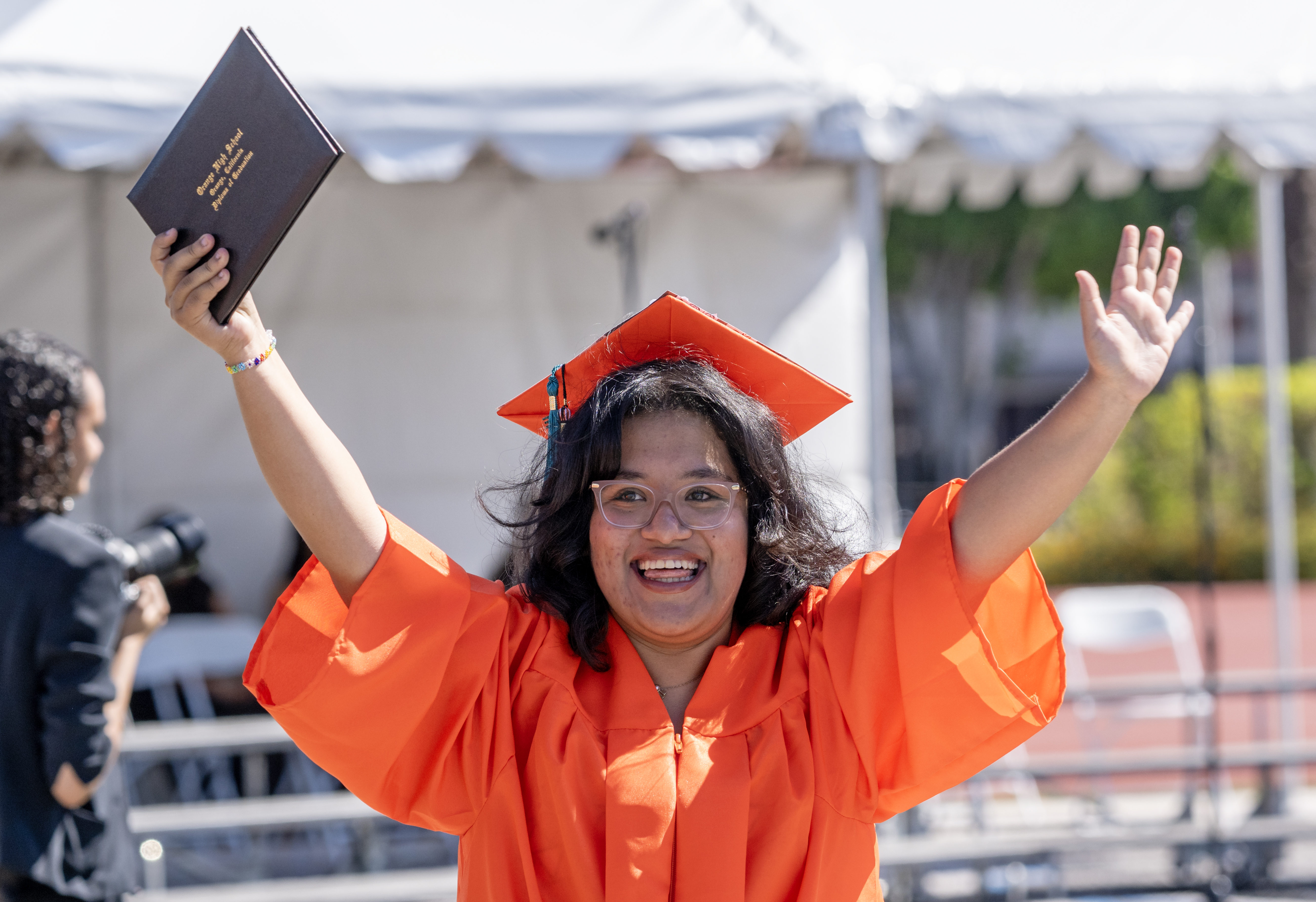 Abigail Godinez celebrates with her new diploma after walking across...
