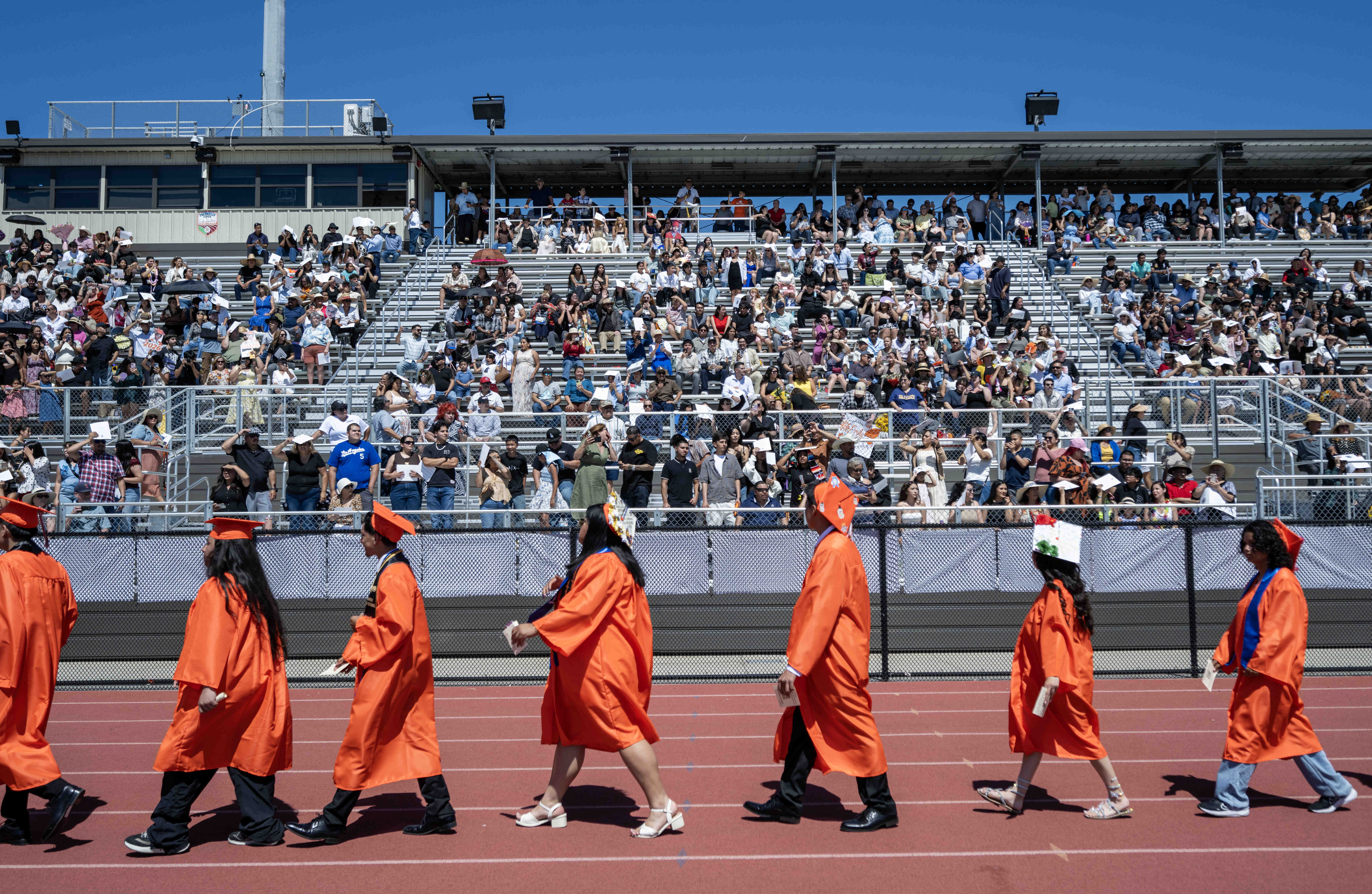 Graduates file into the stadium during the processional at Orange...
