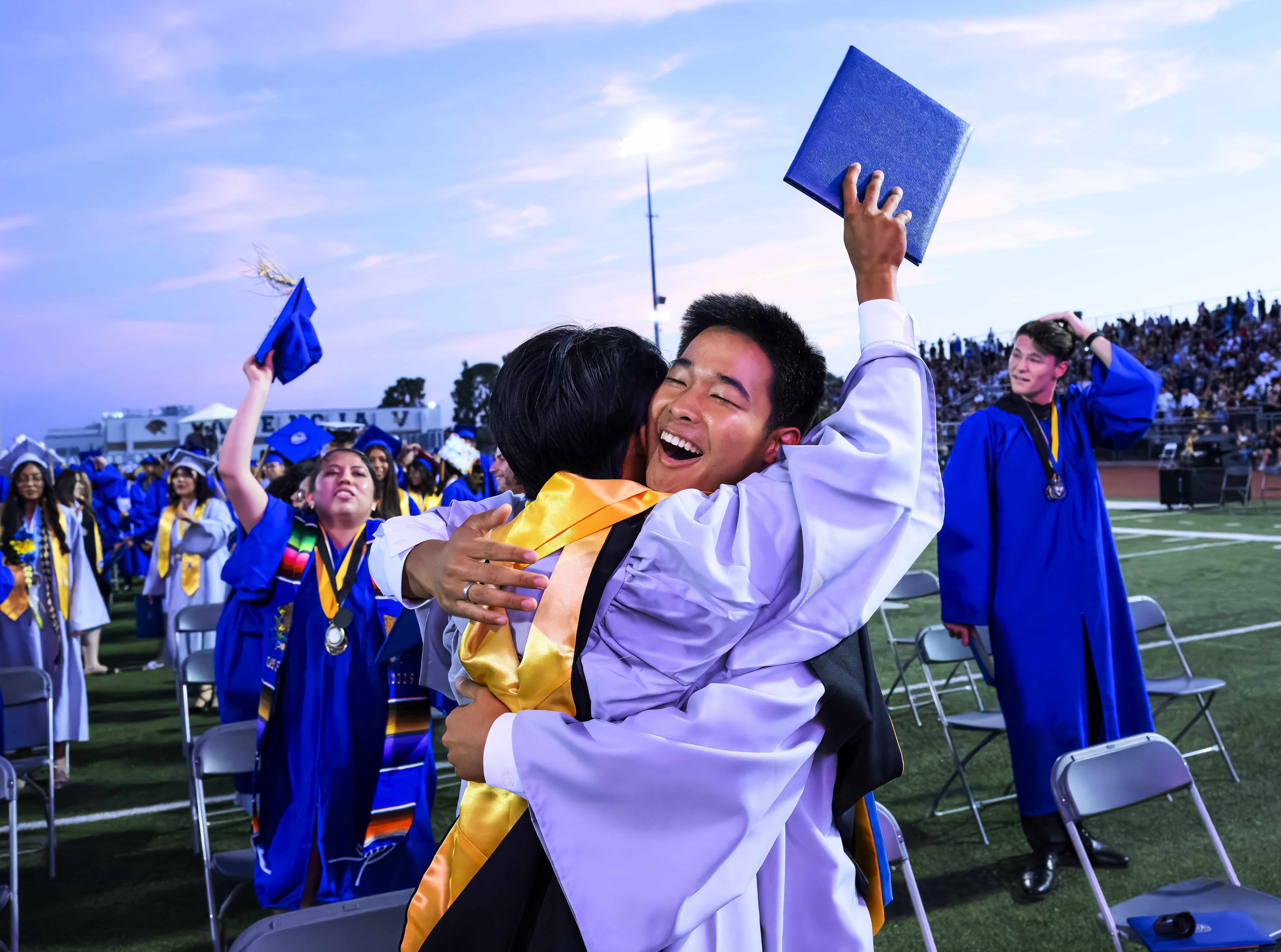 Jason Chun, center, hugs a fellow graduate following the Valencia...
