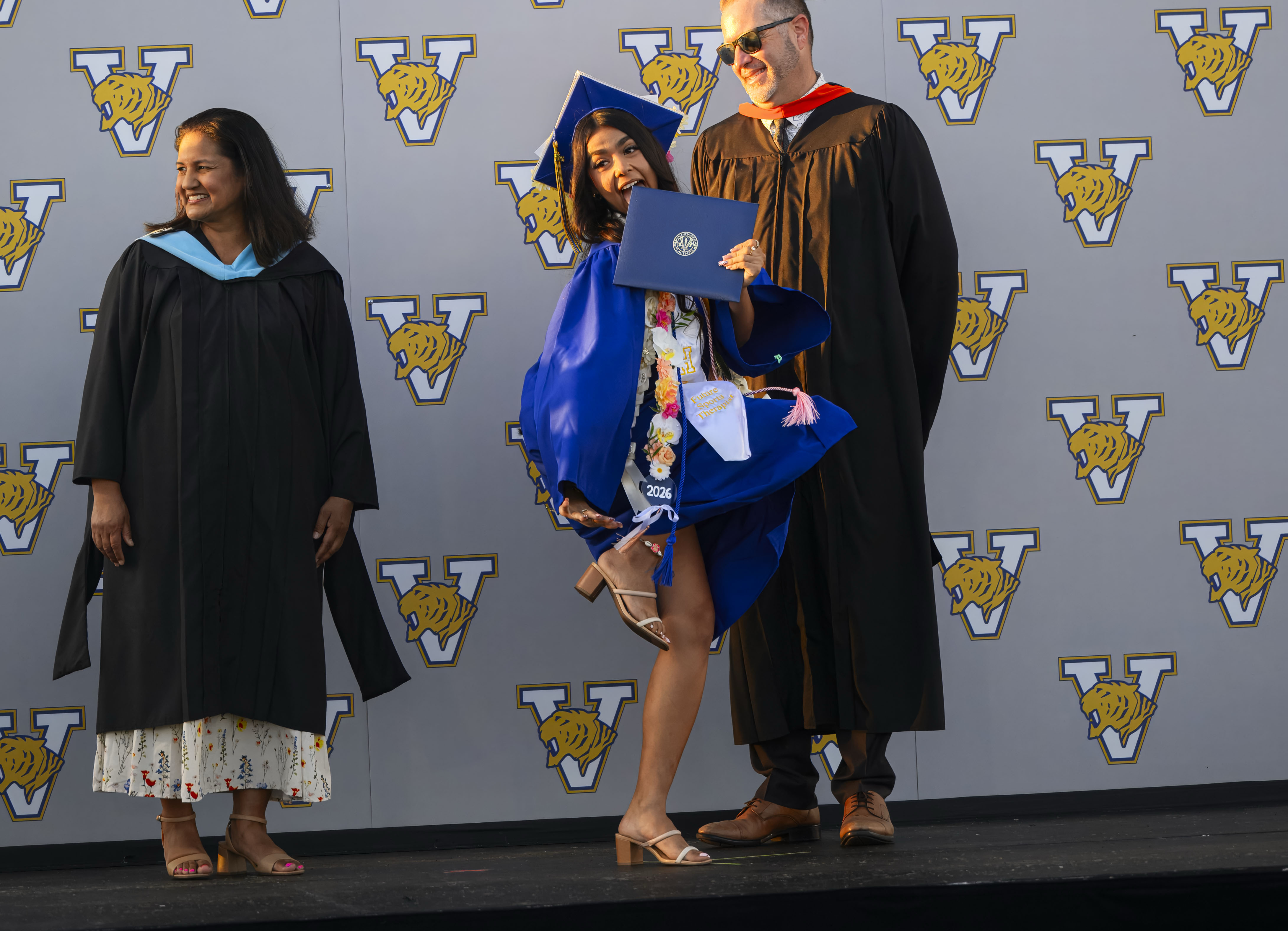 Graduate Delilah Castellanos, center, does a little dance as she...
