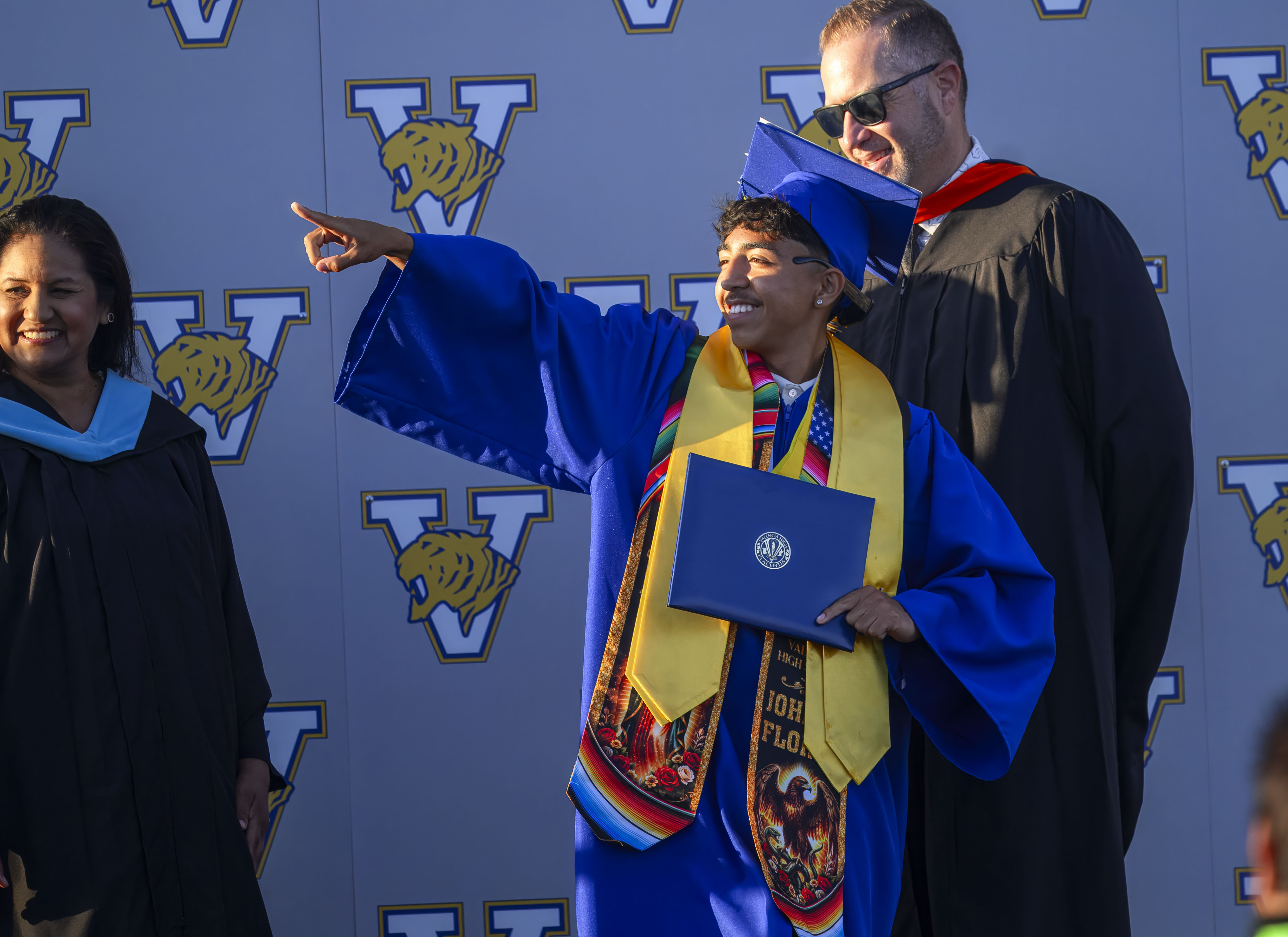 Graduate Johnny Flores motions to his family as he receives...