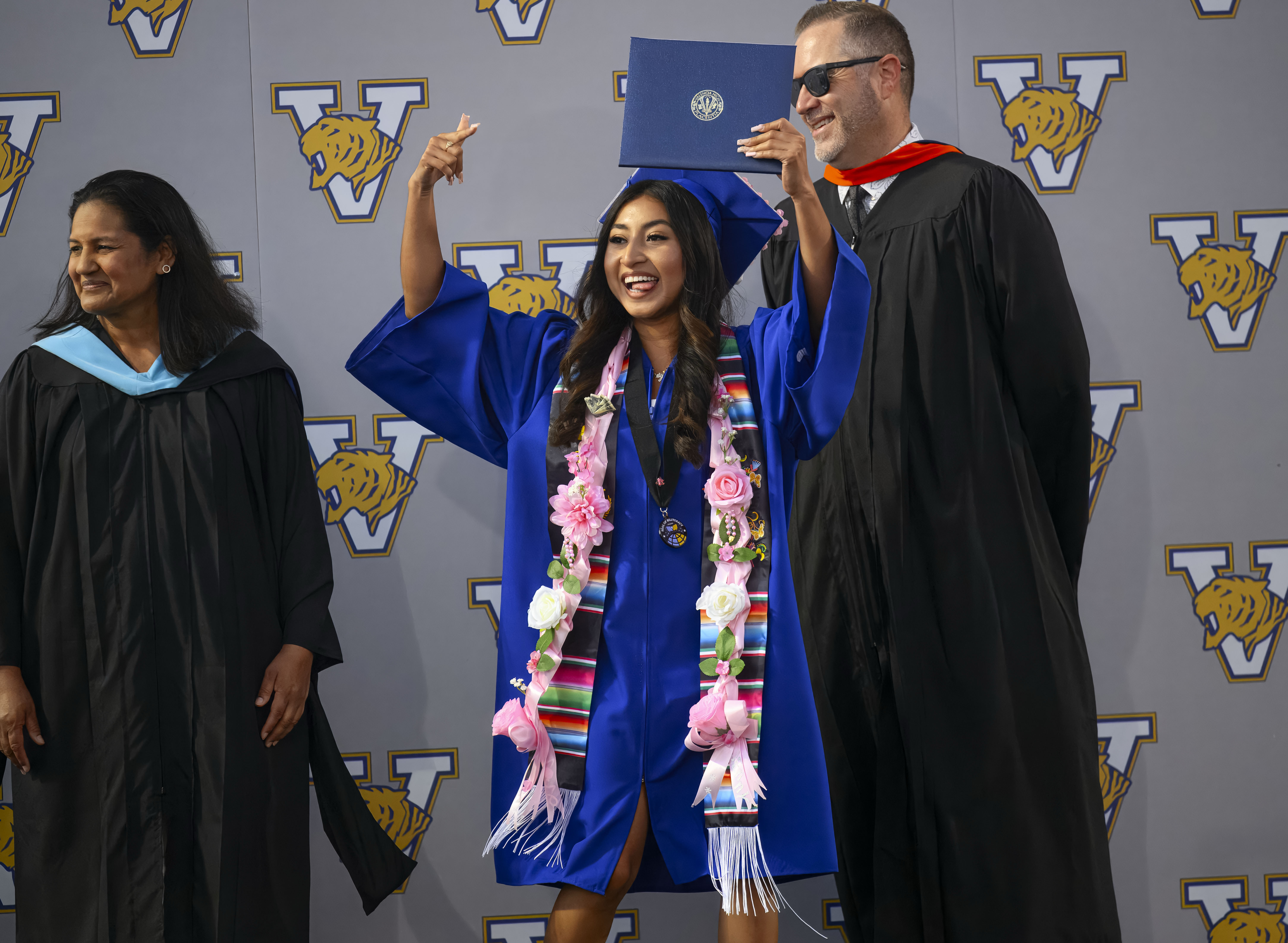 Graduate Jennifer Santana Cuevas shows off her diploma during the...