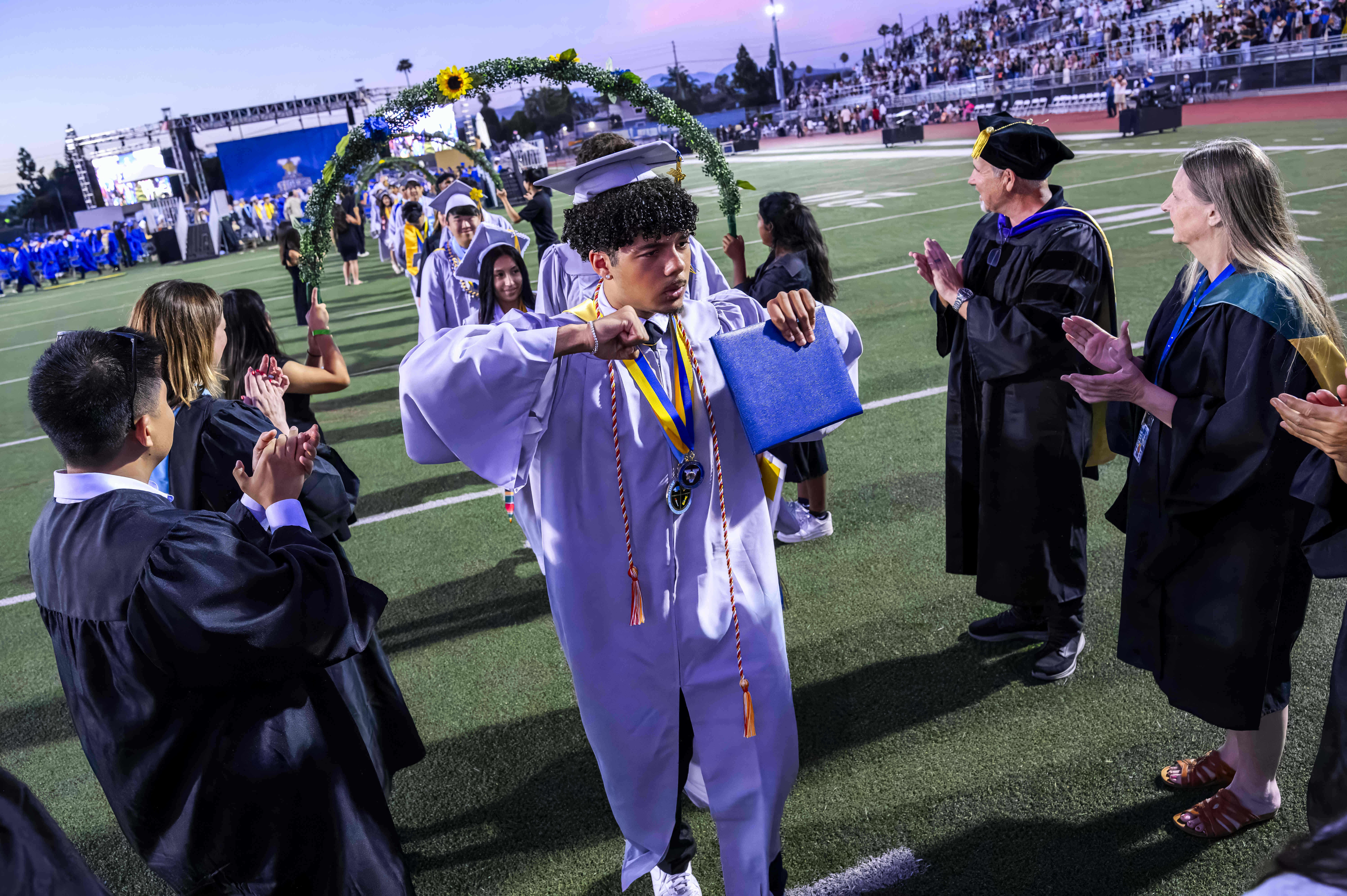 Graduates receive congratulations from teachers as they leave Bradford Stadium...