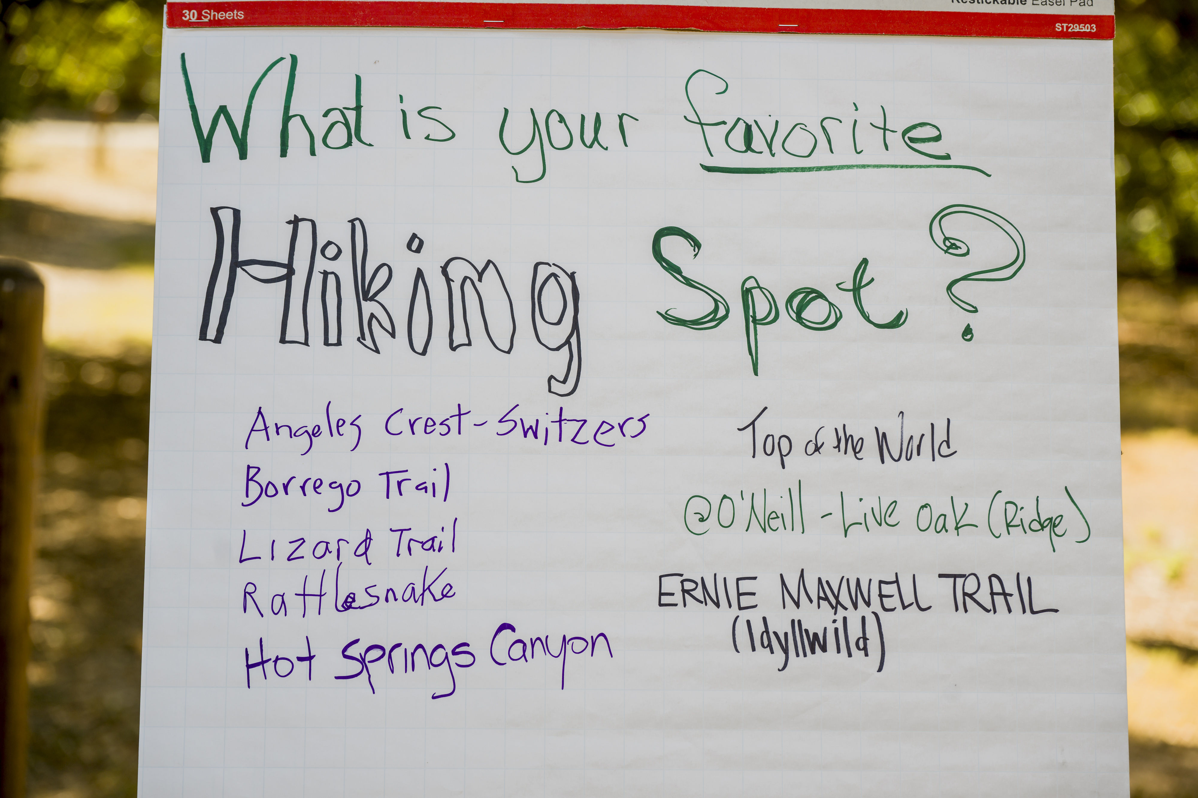 Participants write down their favorite hiking spot on a whiteboard...