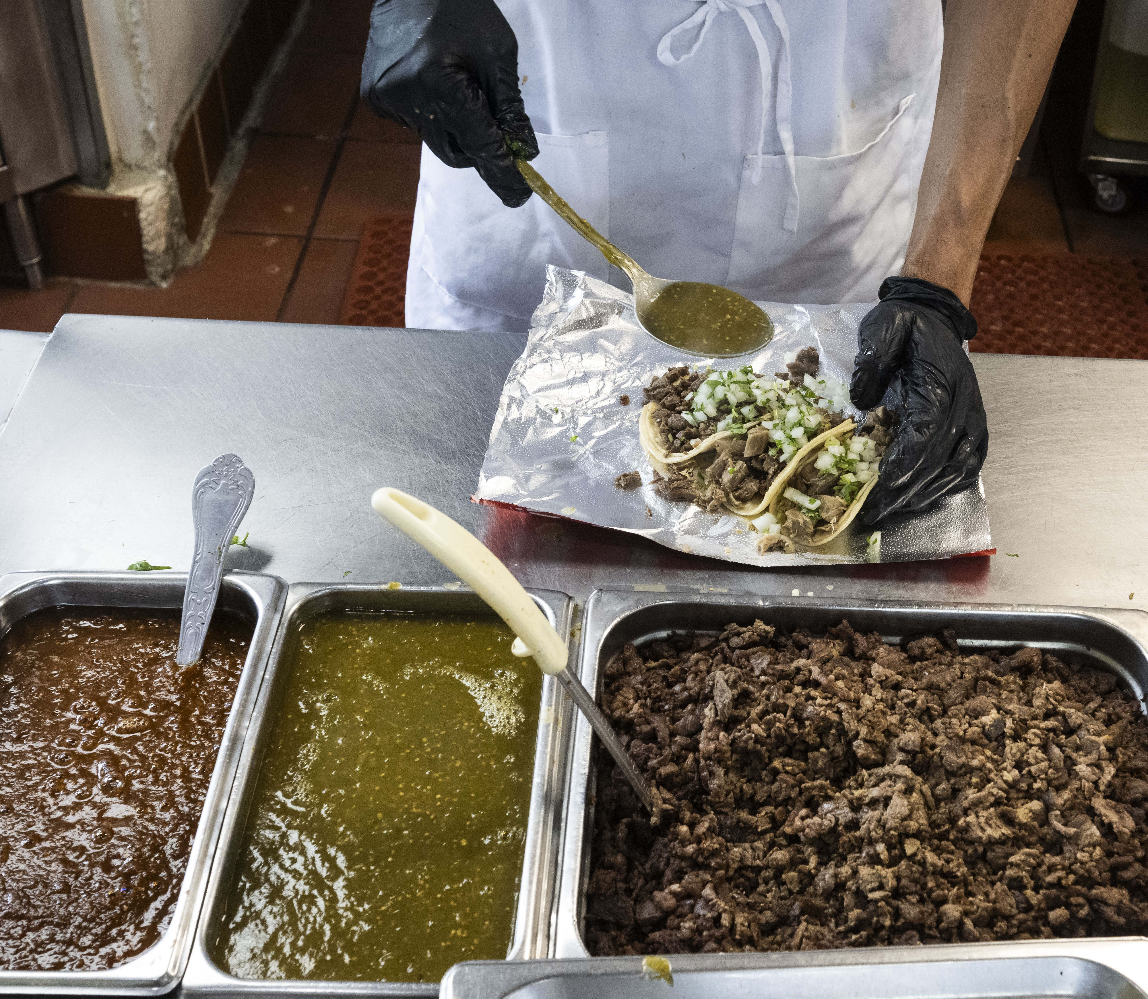 A cook fills a taco order at Taqueria Hoy in...