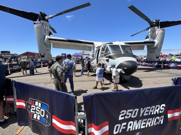 Lt. Justin Price directs NASCAR fans toward the CMV-22B Osprey that they will able to tour. (Kirk Kenney / San Diego Union-Tribune)