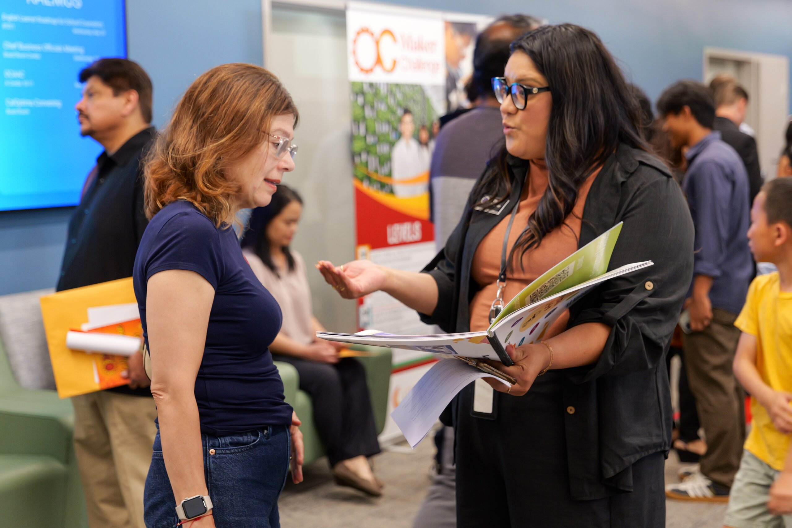 OCDE staff speak with attendees at the annual ocMaker Challenge awards ceremony in the OCDE Conference Center.
