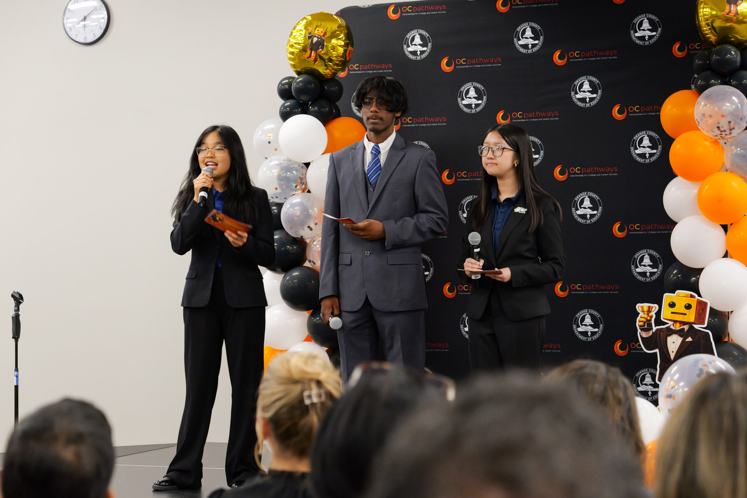 OC Pathways student ambassadors Sophia, Aahan and Donna announce the awards categories at the ocMaker Challenge awards ceremony.