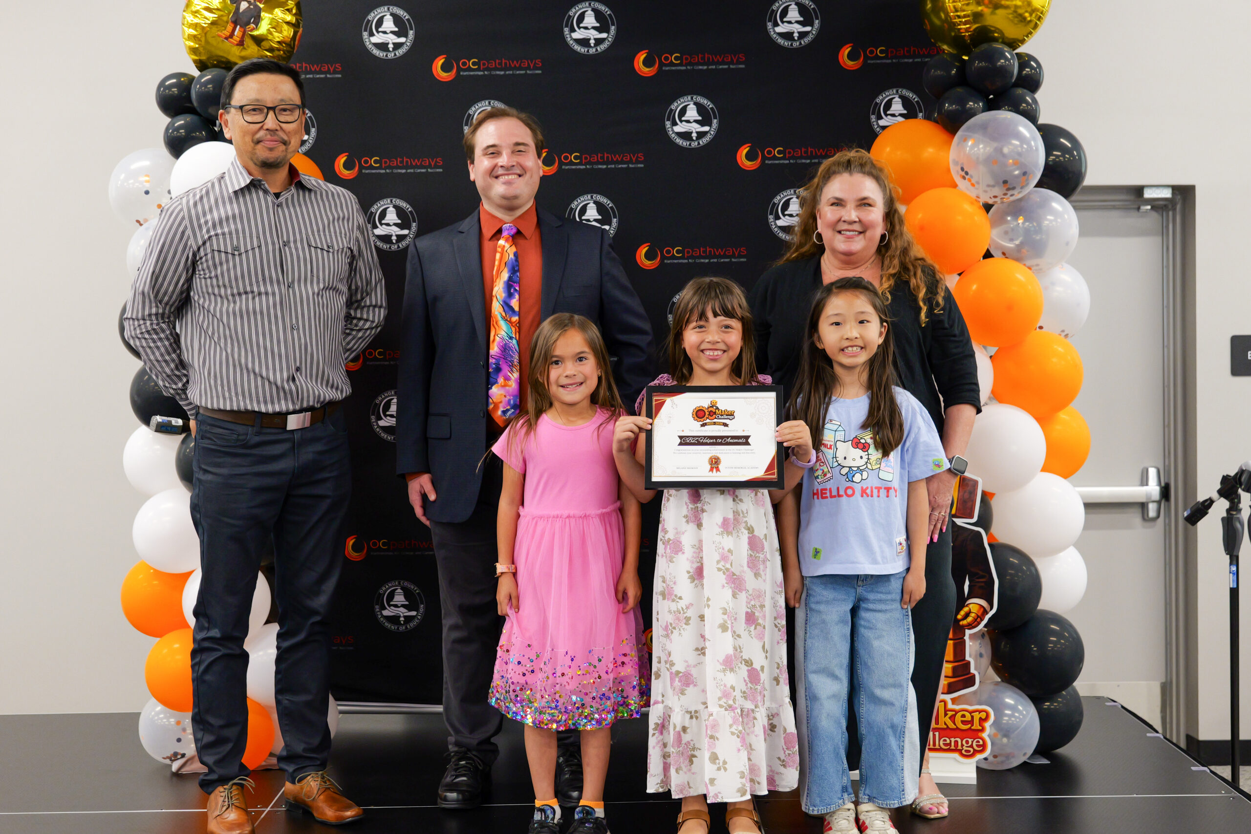 Tustin Memorial Academy students Brooklyn, Charlotte and Zoey accept their first-place award for their static prototype project at the ocMaker Challenge awards ceremony in the OCDE Conference Center.