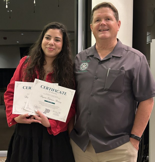 Poway High Class of 2026 graduate Dayana Espinoza Ramirez accepts her scholarship awards at the Poway High Alumni Association ceremony with the association's President Larry Ott. (Courtesy Poway High Alumni Association)