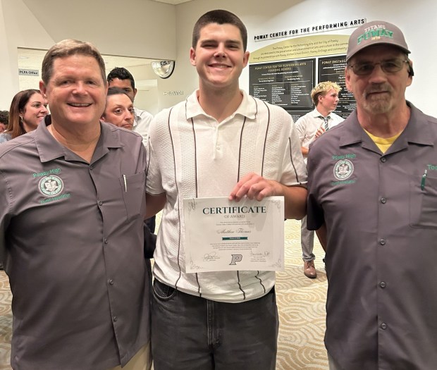 Poway High Class of 2026 graduate Matthew Thomas, center, accepts his Poway High Alumni Association scholarship with association representatives. (Courtesy Poway High Alumni Association)