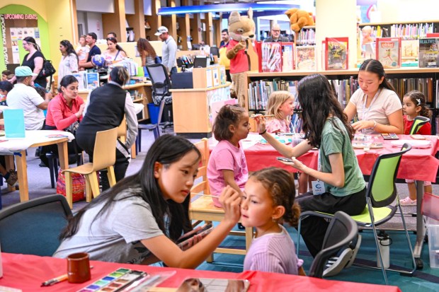 Teen volunteers Sofie Zhao, Amy Wu and Claire Wong, all members of the "Smile and Paint" youth club, provided free face painting for children. (Criselda Yee)