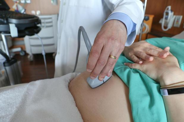 FILE - A doctor performs an ultrasound scan on a pregnant woman at a hospital in Chicago on Aug. 7, 2018. (AP Photo/Teresa Crawford, File)