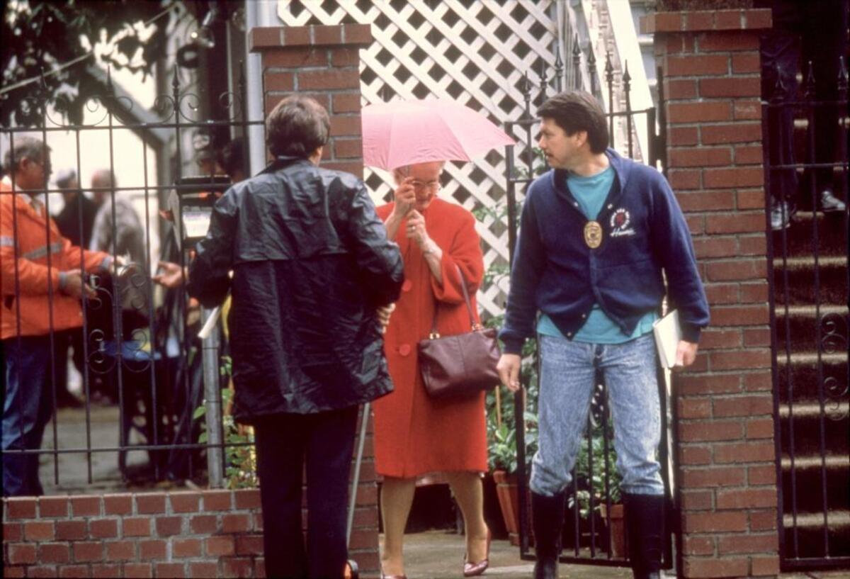 Dorothea Puente leaves her F Street boarding house on Nov. 12, 1988, walking past homicide Detective John Cabrera, right, as Sacramento police officers began searching her yard for bodies. Puente did not return and was arrested five days later in Los Angeles.