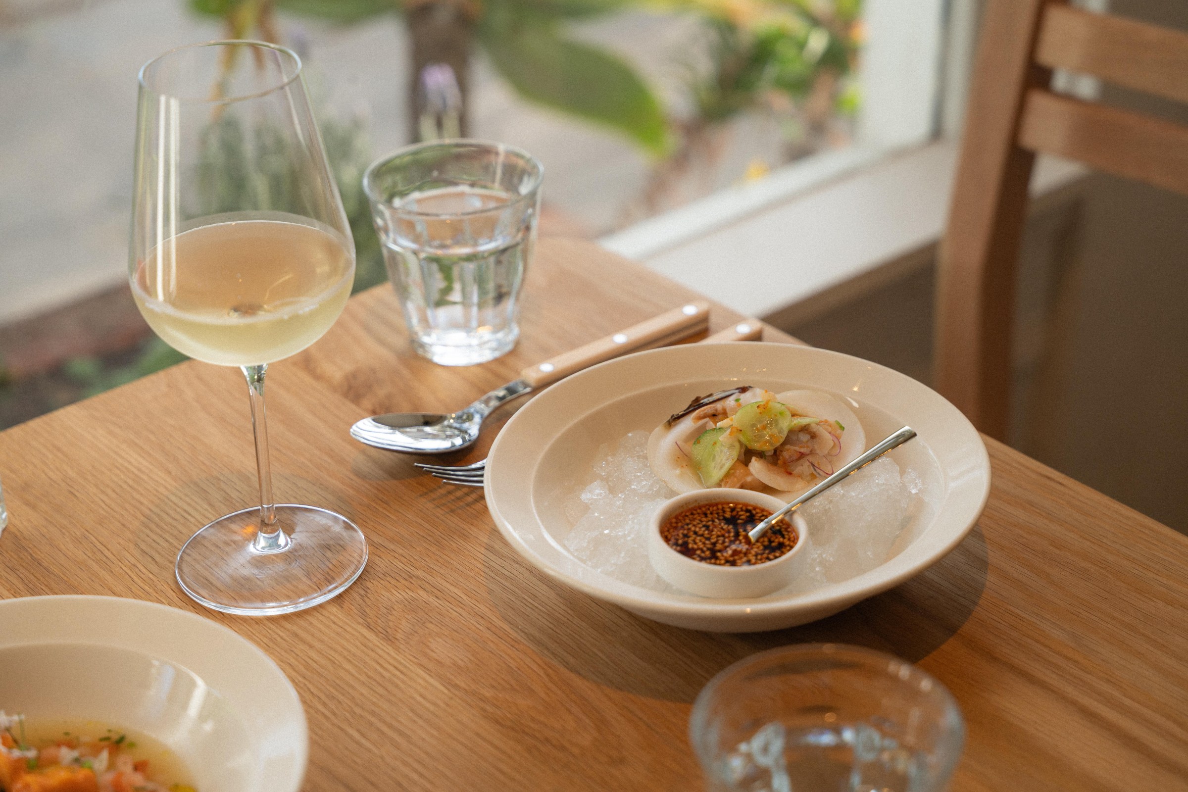 Clam, cucumber, and salsa macha on a white plate at San Damian.