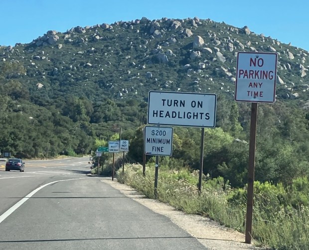 "No Parking" and "Turn on Headlights" signs alert drivers to parking rules at state Route 67 near Mt. Woodson Gateway County Preserve. (Kristi Mansolf)