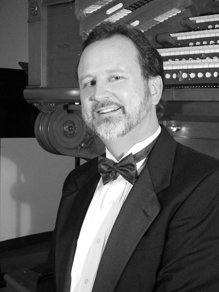 black and white headshot of man in tuxedo 