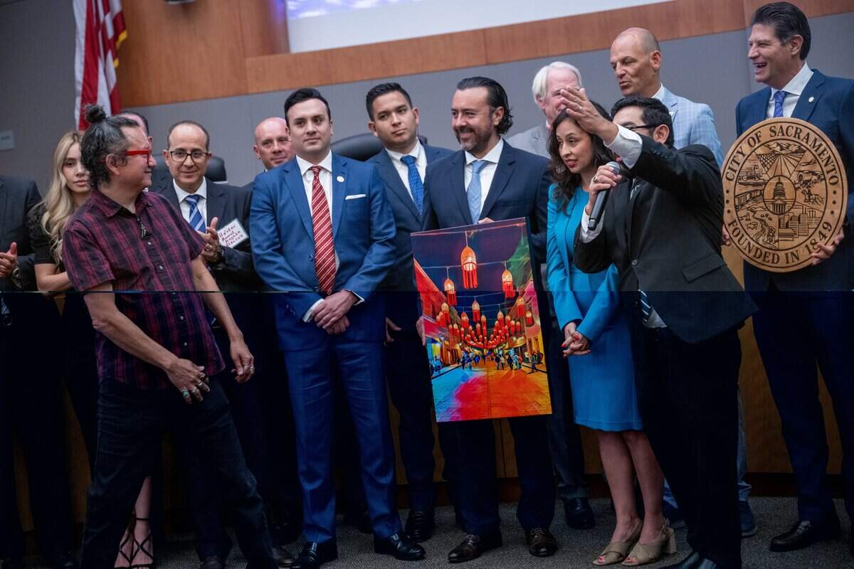 Ruben Reveles looks at his artwork made for Morelia Mayor Alfonso Martínez Alcázar, far right, as he stands alongside members of the Sacramento City Council during a sister city celebration at Sacramento's City Hall on Thursday.