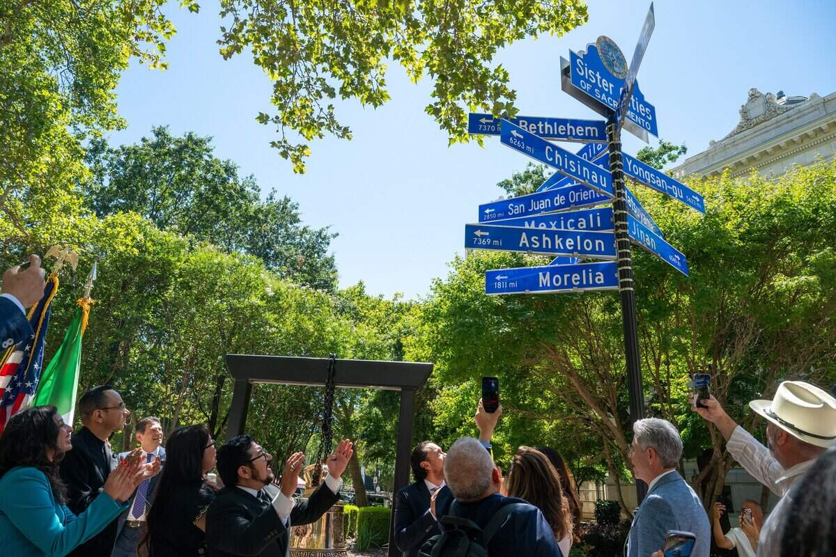 Councilmember Eric Guerra, center, reacts after the sister city sign for Morelia, Mexico, is unveiled at Sacramento City Hall on Thursday.
