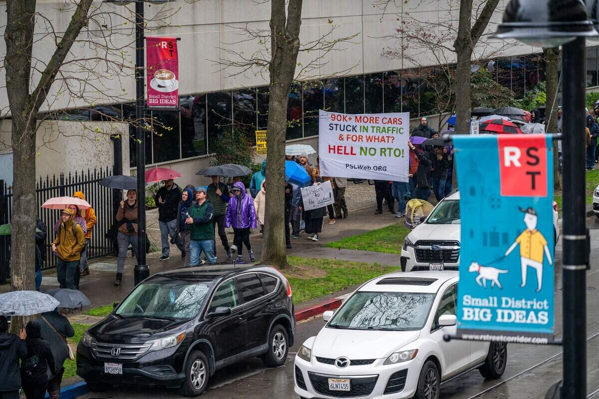 State workers march holding signs around the CalHR offices in March 2025 in Sacramento protesting Gov. Gavin Newsom’s order requiring most state employees to work in the office four days a week. The requirement begins Wednesday for thousands of state workers, many of whom say the added commuting costs and time are driving them to consider transit, vanpools and bicycles.