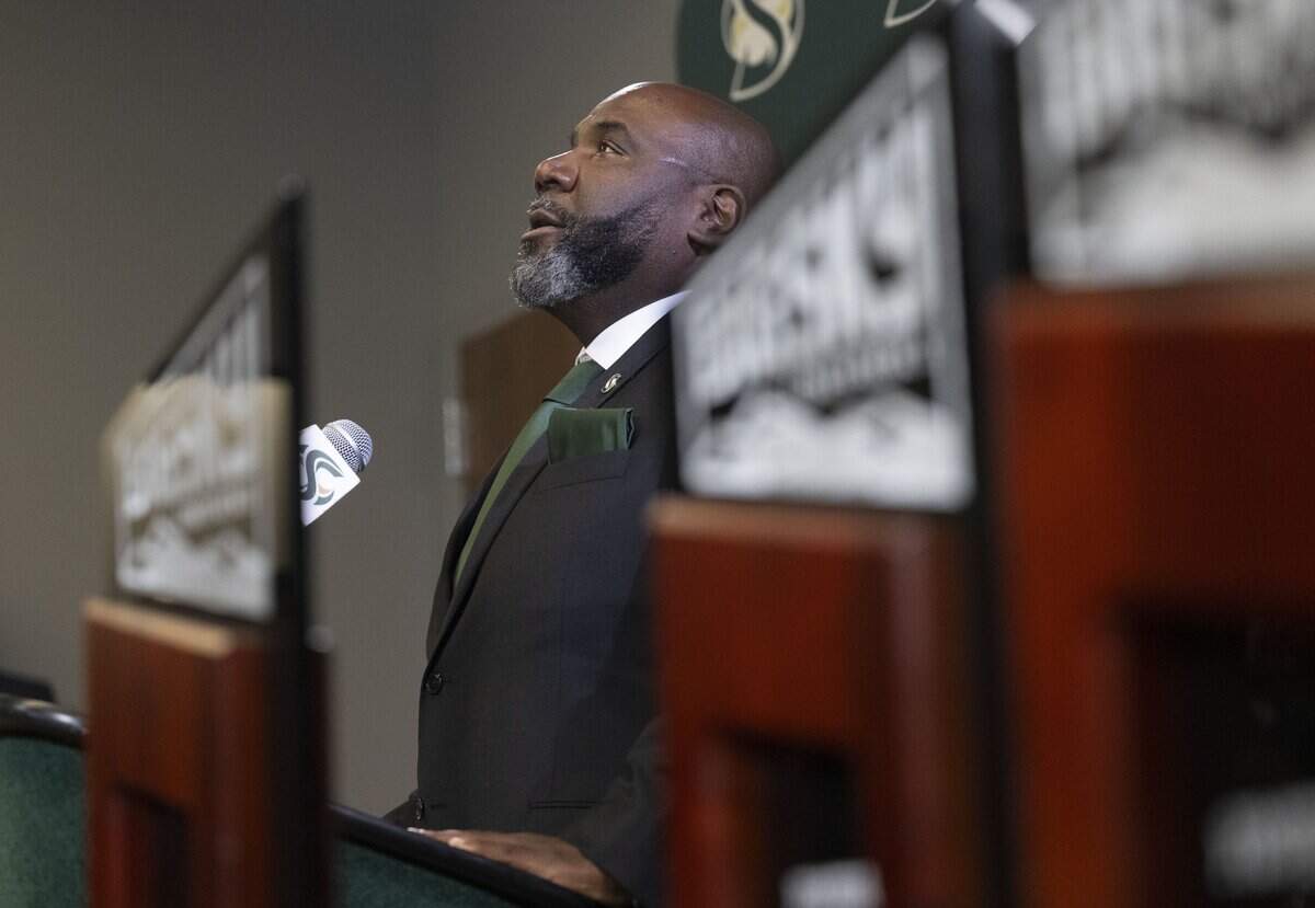 New Sacramento State football coach Alonzo Carter, framed by Big Sky championship trophies from previous seasons, acknowledges his late mother during an introductory press conference on Thursday, Dec. 18. Carter is the university's 14th head football coach.