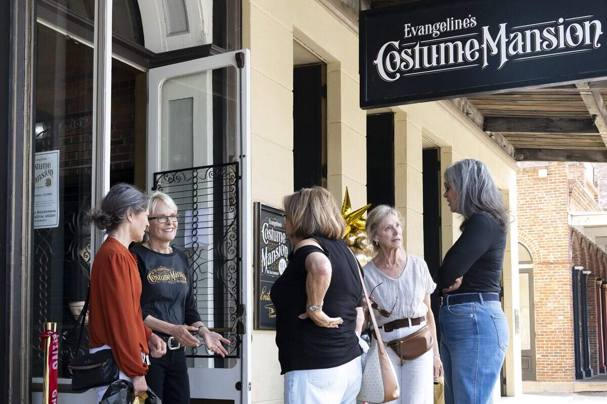 Evangeline’s Costume Mansion owner Deborah Chaussé, second from left, chats with visitors during the store’s grand reopening in Old Sacramento on Friday, June 26, 2026. The store had been closed for just over a year due to fire damage.