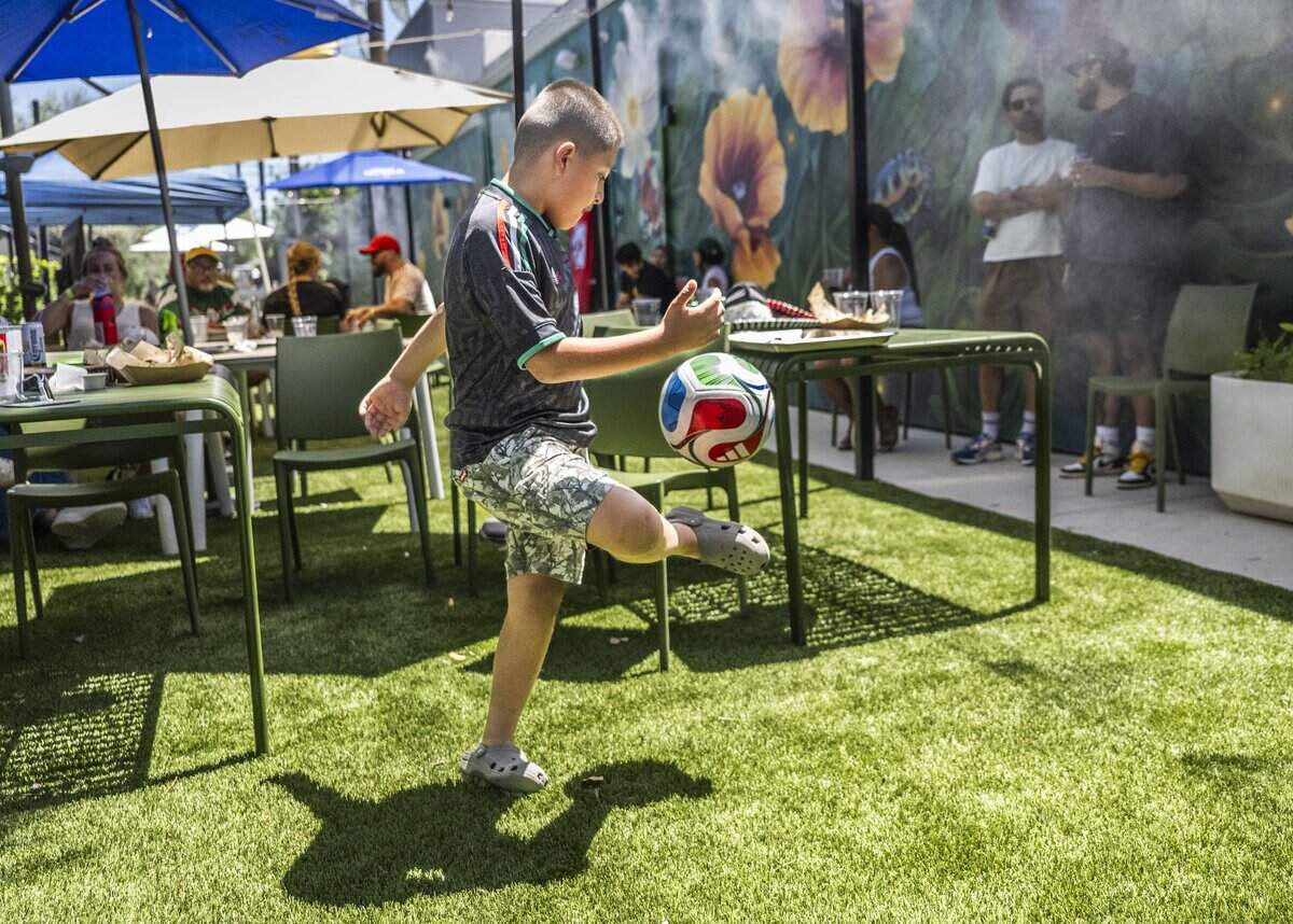 Noah Cruz, 7, of Sacramento plays with a World Cup soccer ball during a World Cup watch party at Garden at the Line in Sacramento on Thursday, June 11, 2026.