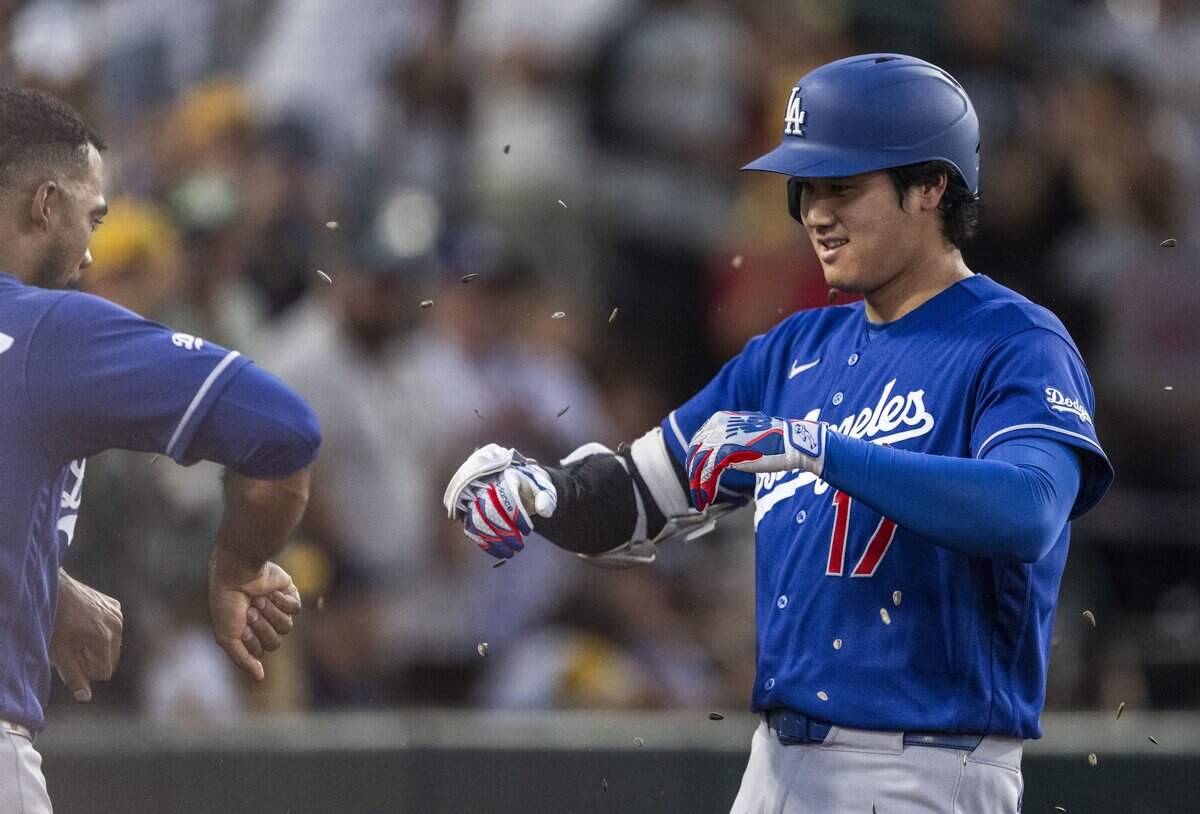 Los Angeles Dodgers' designated hitter Shohei Ohtani (17) gets sunflower seeds thrown at him by teammate outfielder Teoscar Hernández (37) after hitting a home run against the Athletics on Monday at Sutter Health Park in West Sacramento.