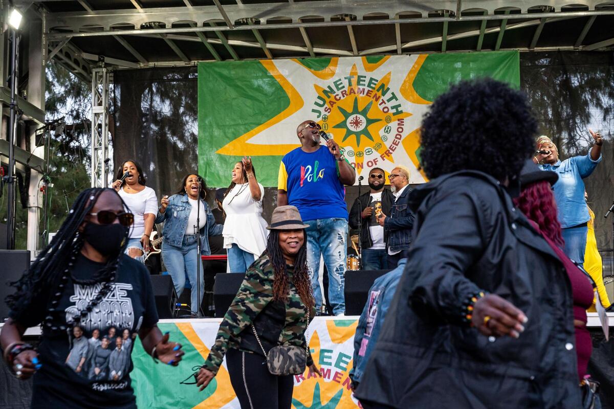 James Jackson, founder of iSound Performing Arts, leads a song onstage during “Gospel Under the Stars,” kicking off Sacramento’s 19th annual Juneteenth festival at William Land Park on Friday, June 17, 2022, in Sacramento.