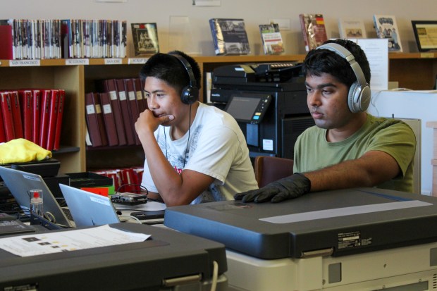 Leonardo Arcias, left, and Shawn Thomas use the California Room's free digitization services on the fifth floor of San Jose's King Library. (Anya Joseph/Mosaic)