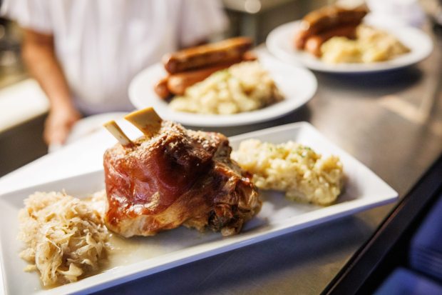 A plate of baked pork shank with potato salad and sauerkraut is prepared during a World Cup watch party at Teske's Germania in San Jose, Calif. (Dai Sugano/Bay Area News Group)